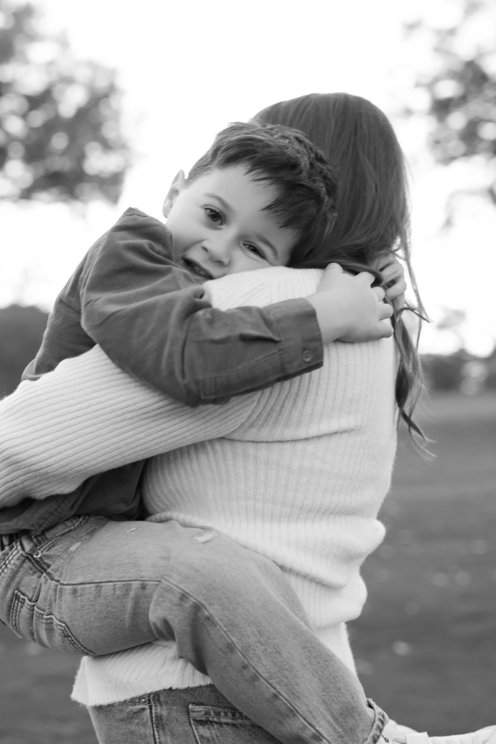 A child hugging their partner with their legs wrapped around them