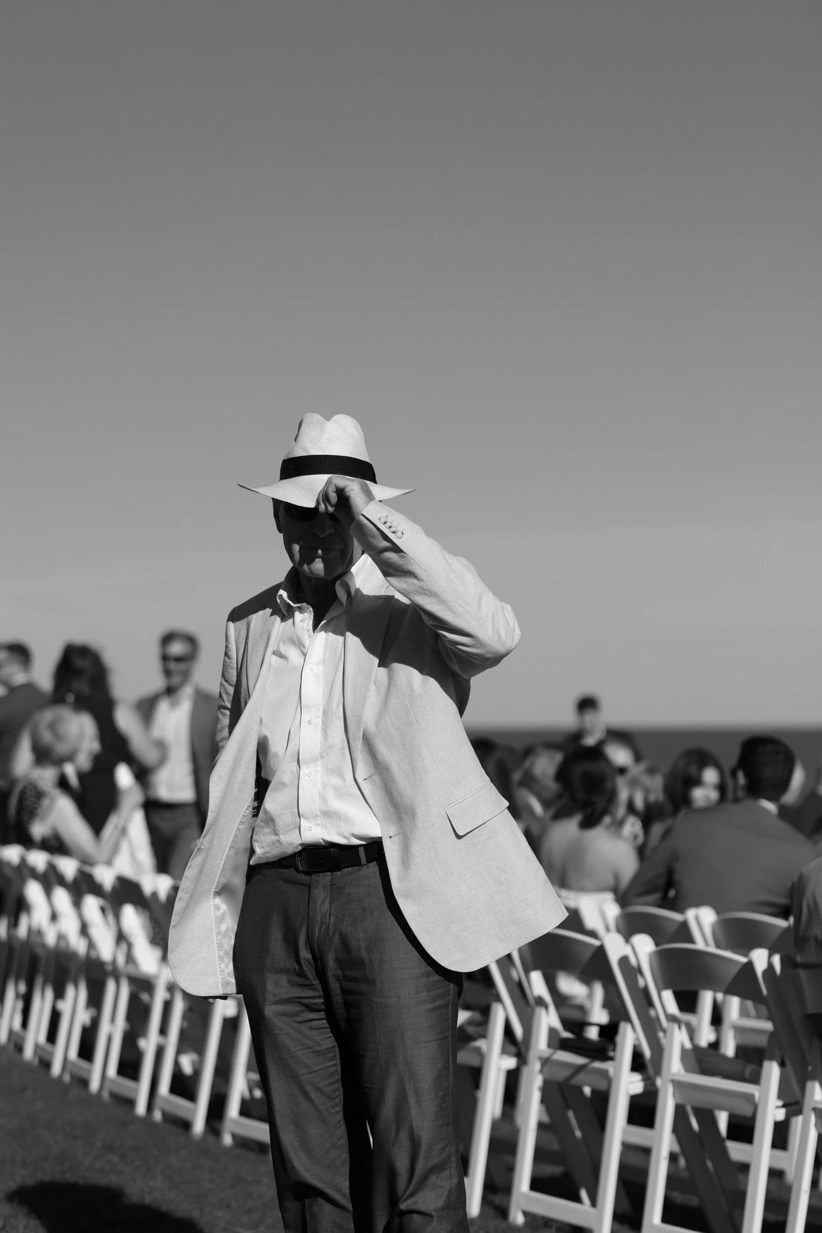  A person in a suit adjusting their hat  