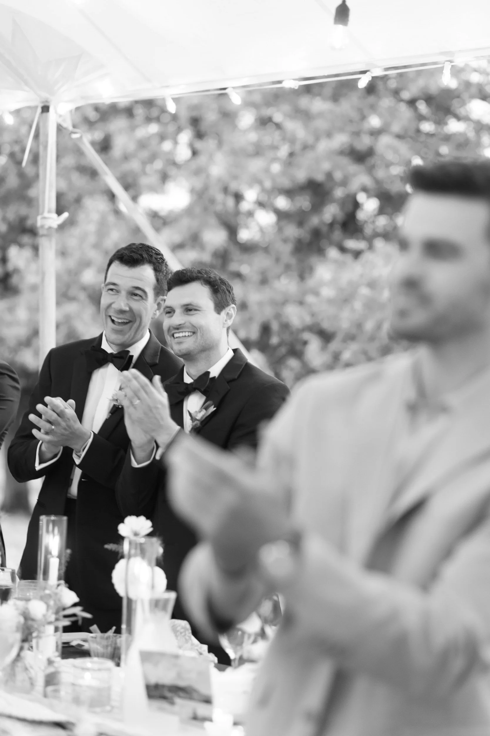 Wedding guests clapping and smiling at a wedding reception 