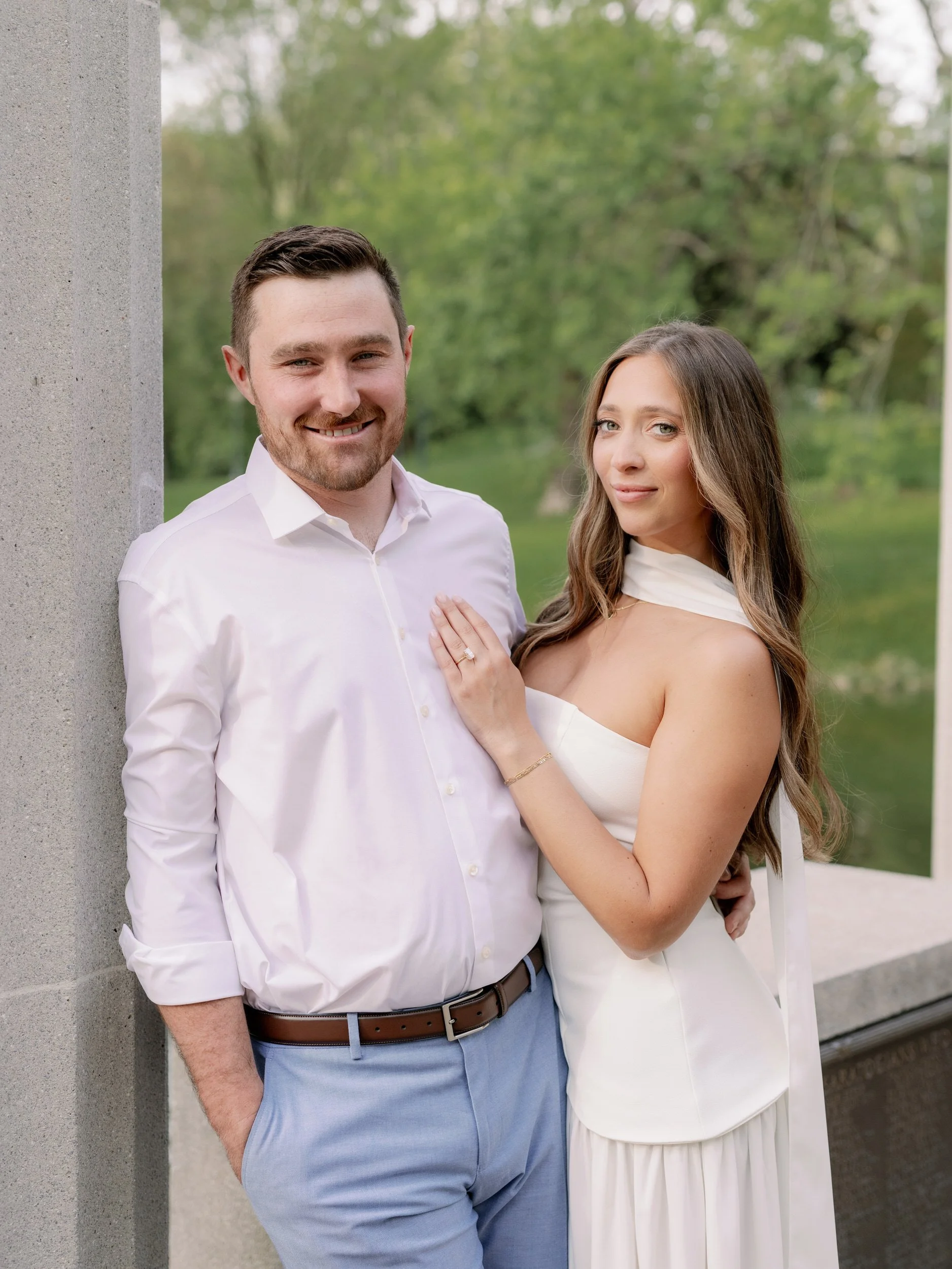 A person leaning on a pillar with their partner standing next to them 