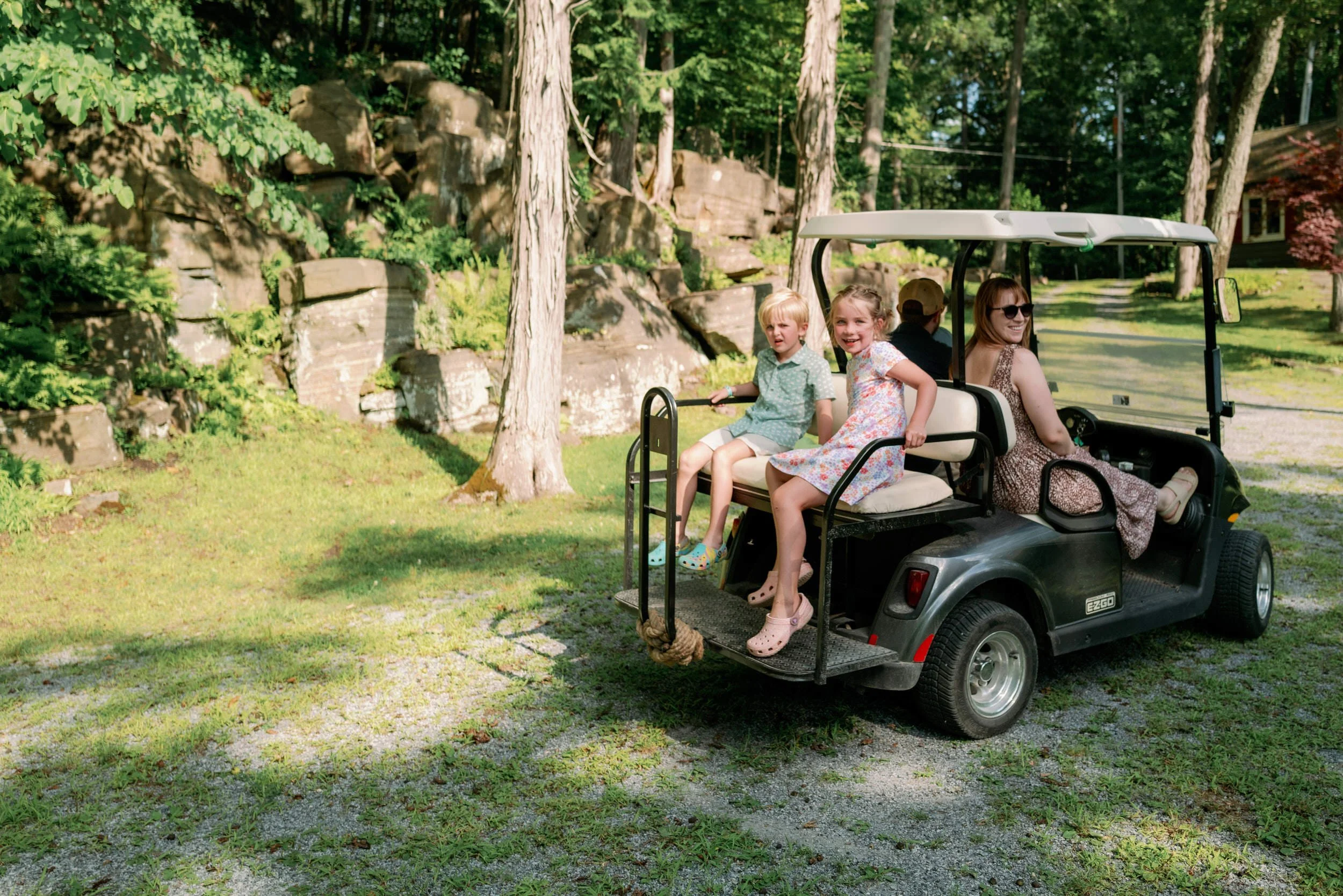 Four people smiling and riding in a golf cart 