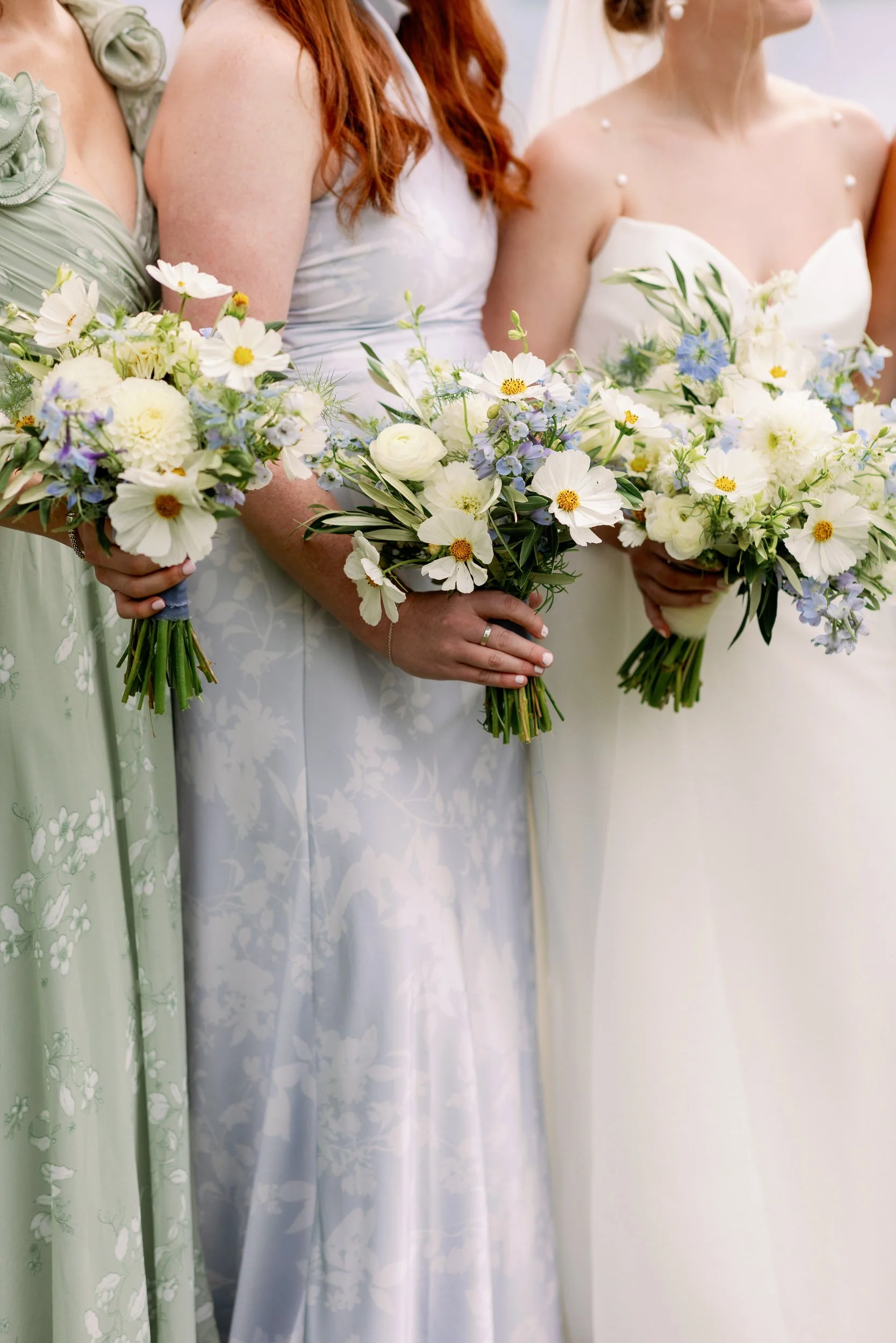 A close up of a newlywed and their wedding party holding bouquets of flowers 