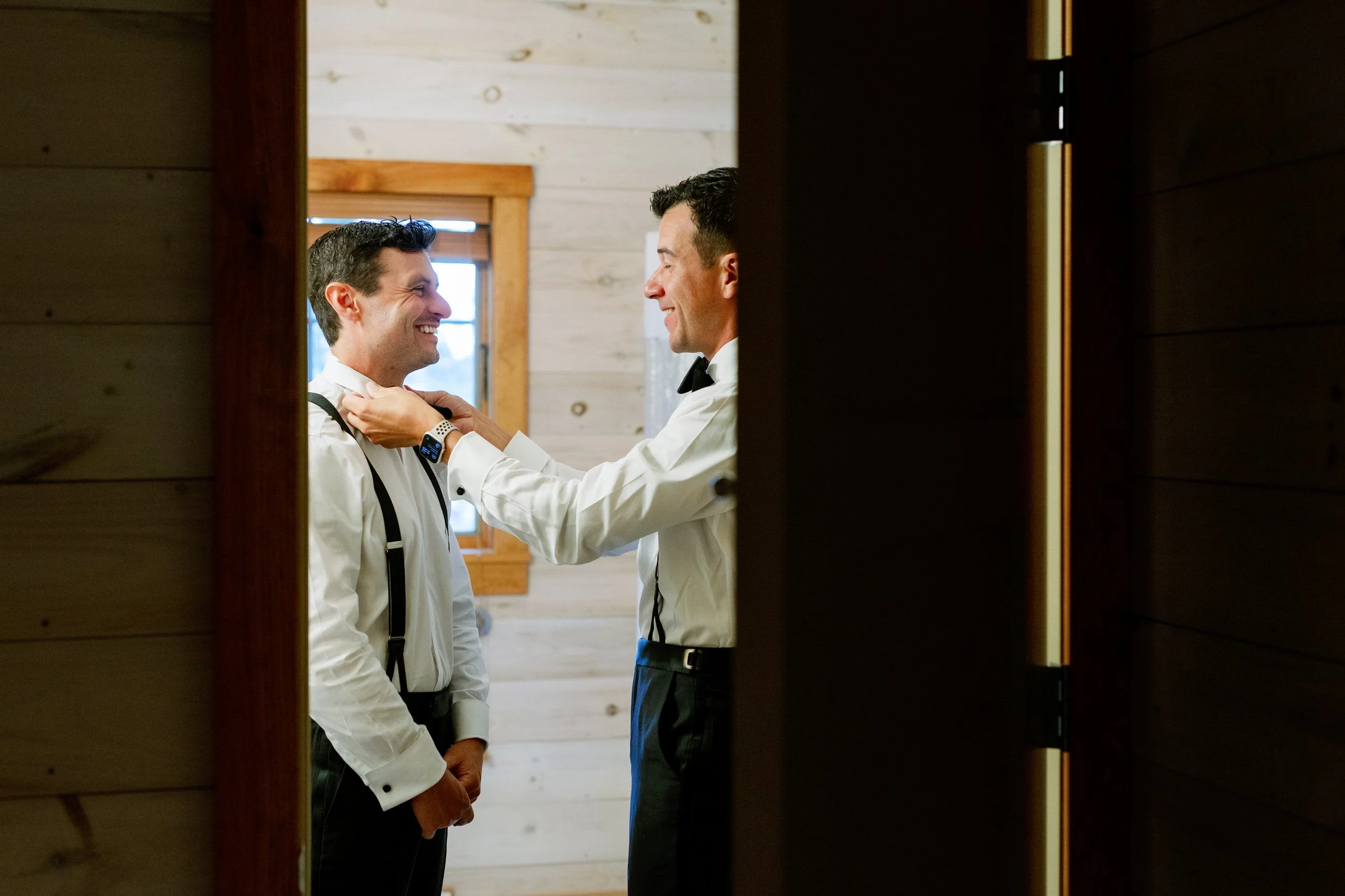 Someone helping a person adjust their suit collar 