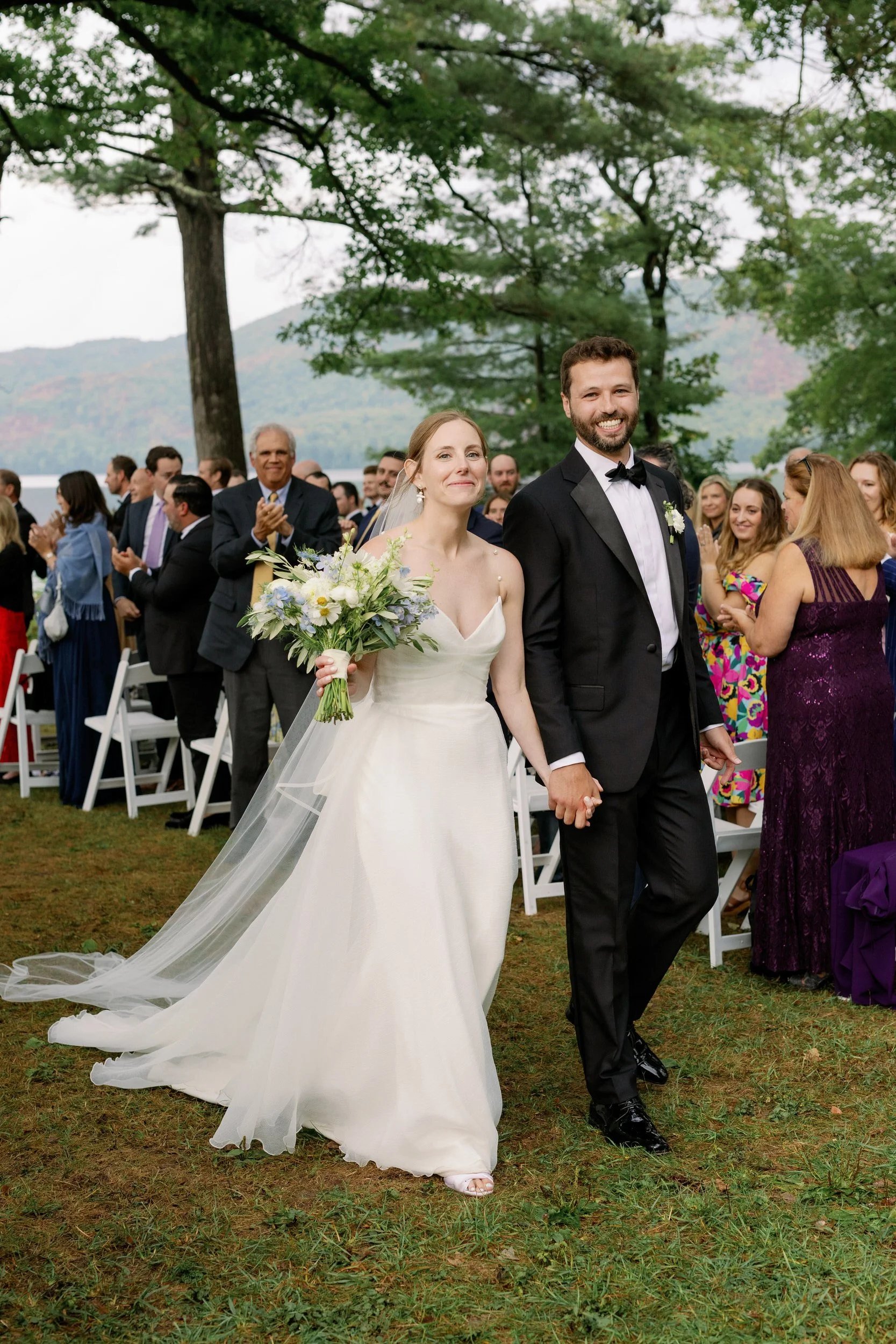 Newlyweds holding hands and walking back up the aisle 