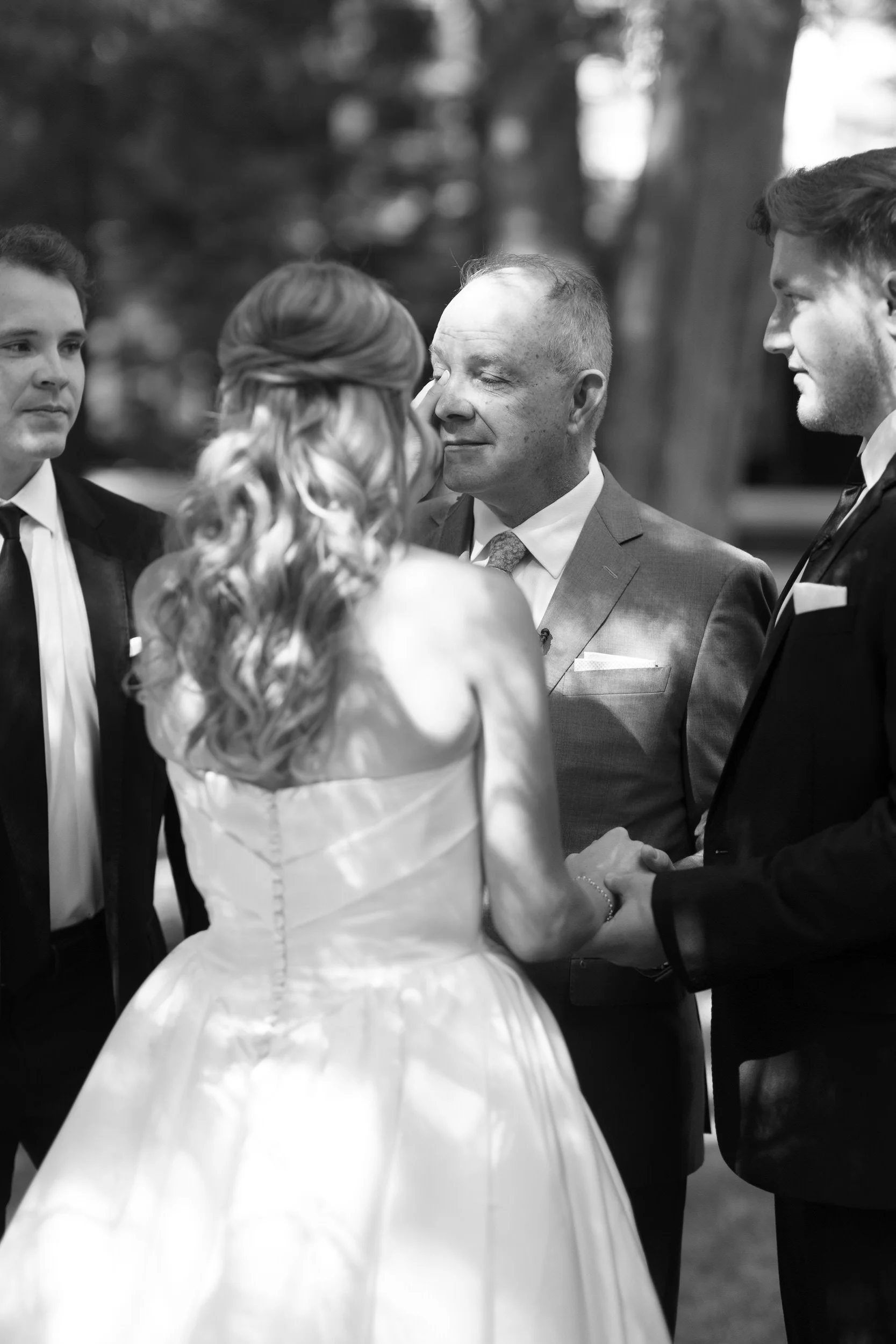 A newlywed being handed off by their parent at their wedding ceremony 
