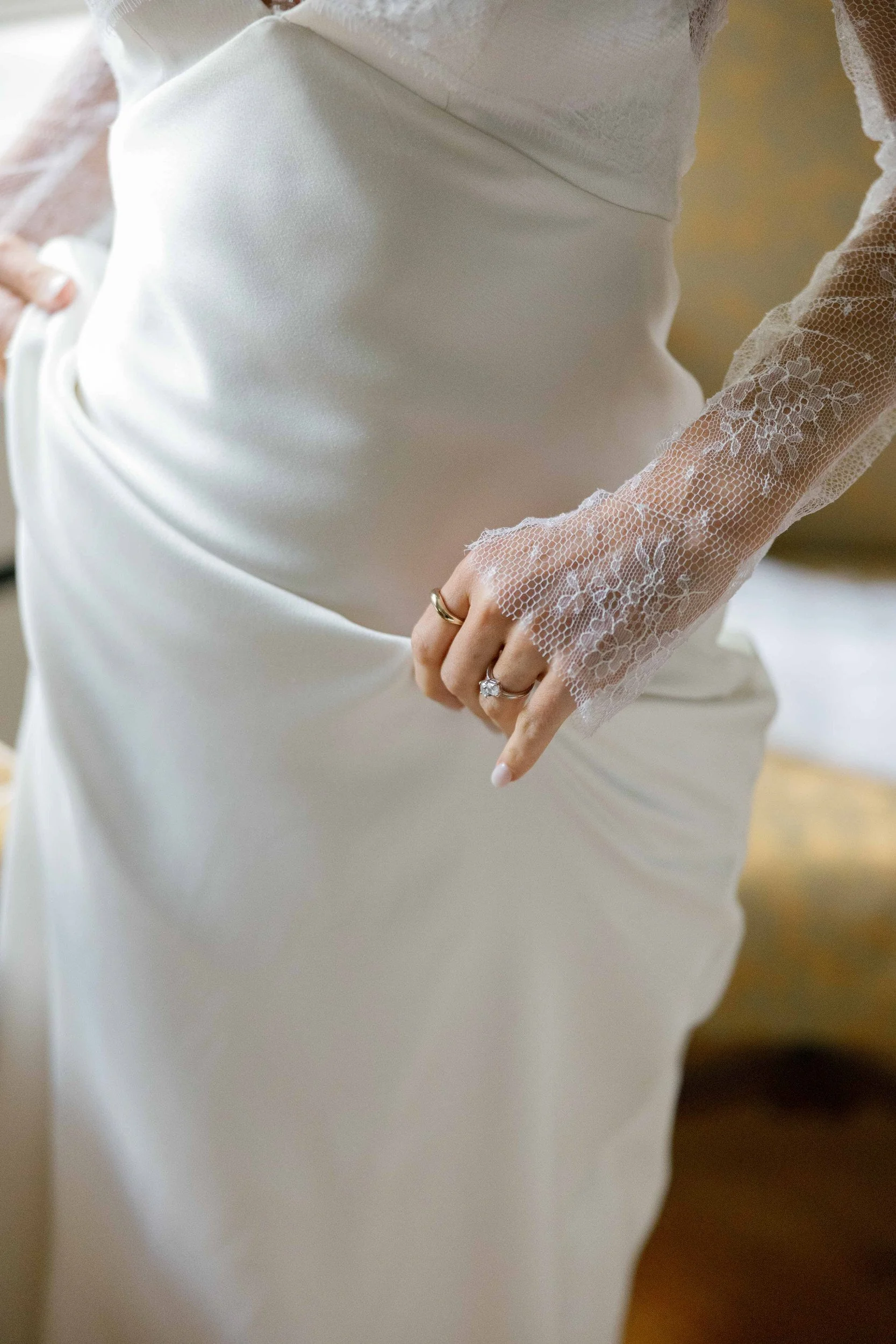 A person in a wedding dress holding the fabric up 