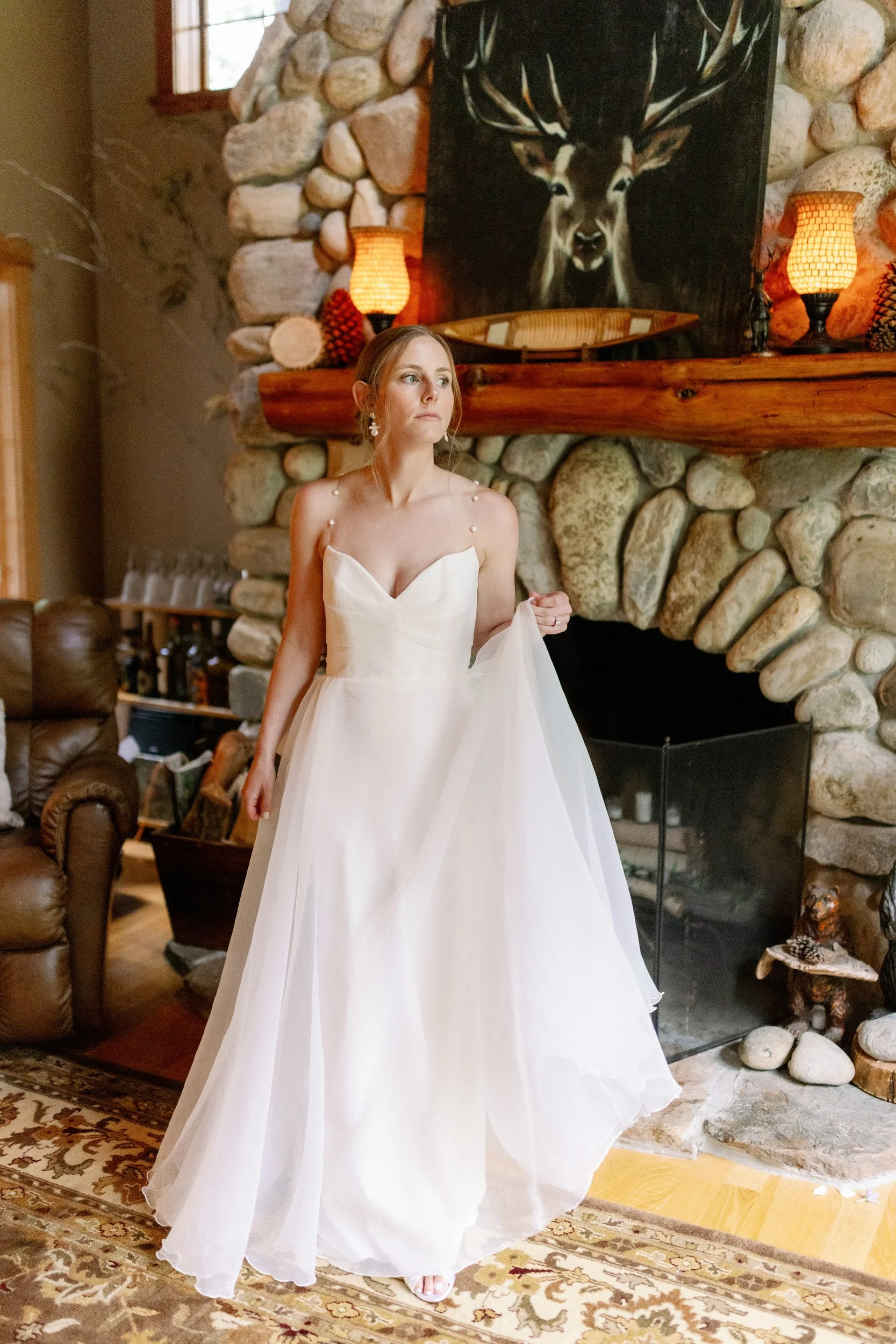 A person in a wedding dress looking to the side as they hold up the bottom of the dress 