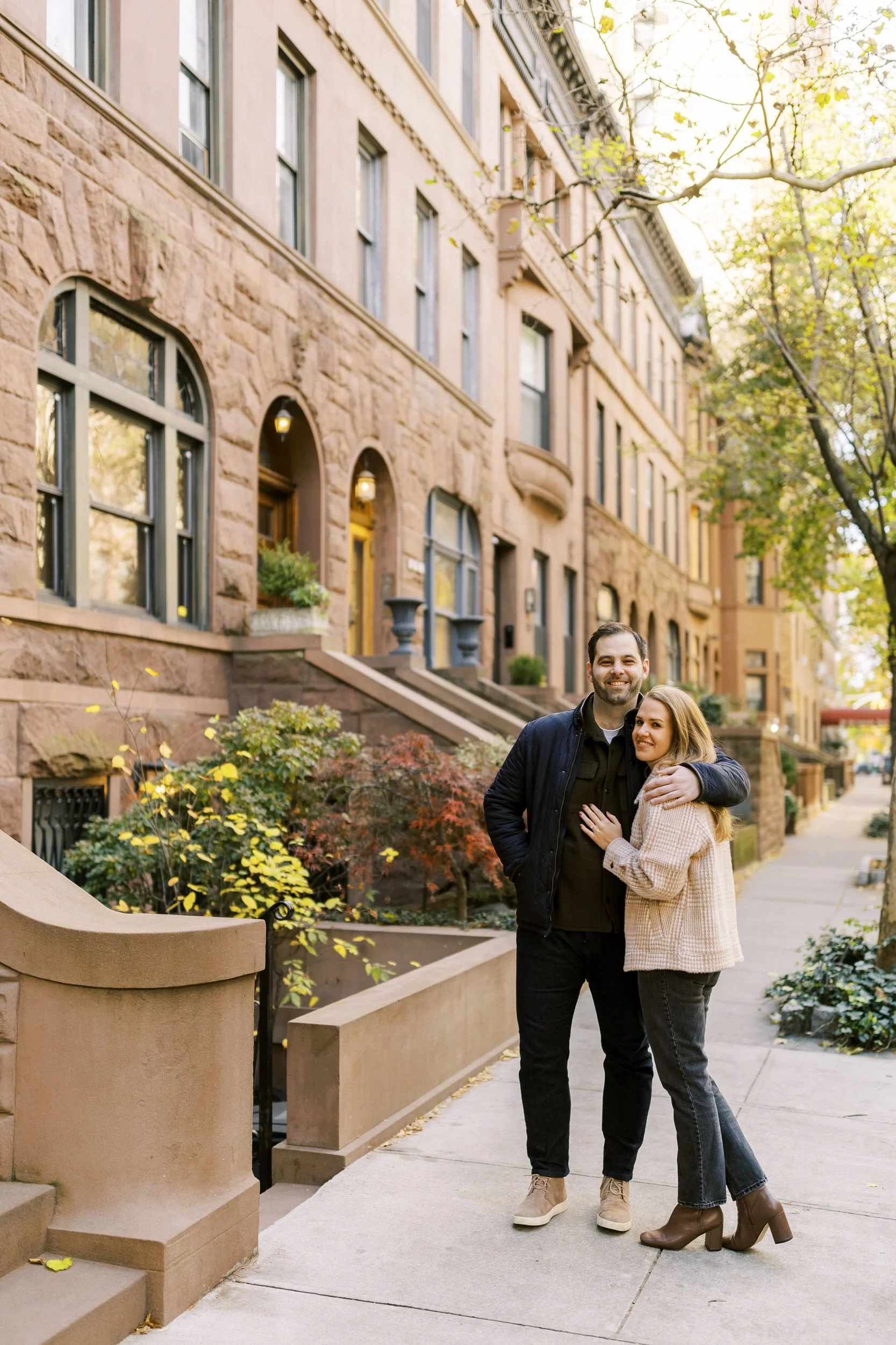 A couple hugging outside of brownstones