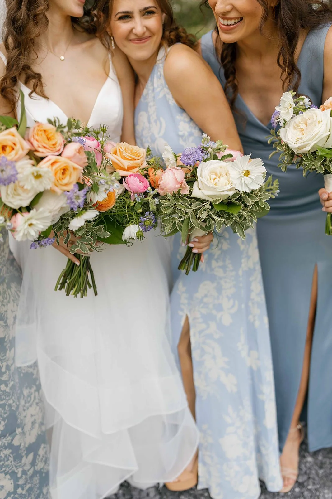 A wedding party hugging a newlywed