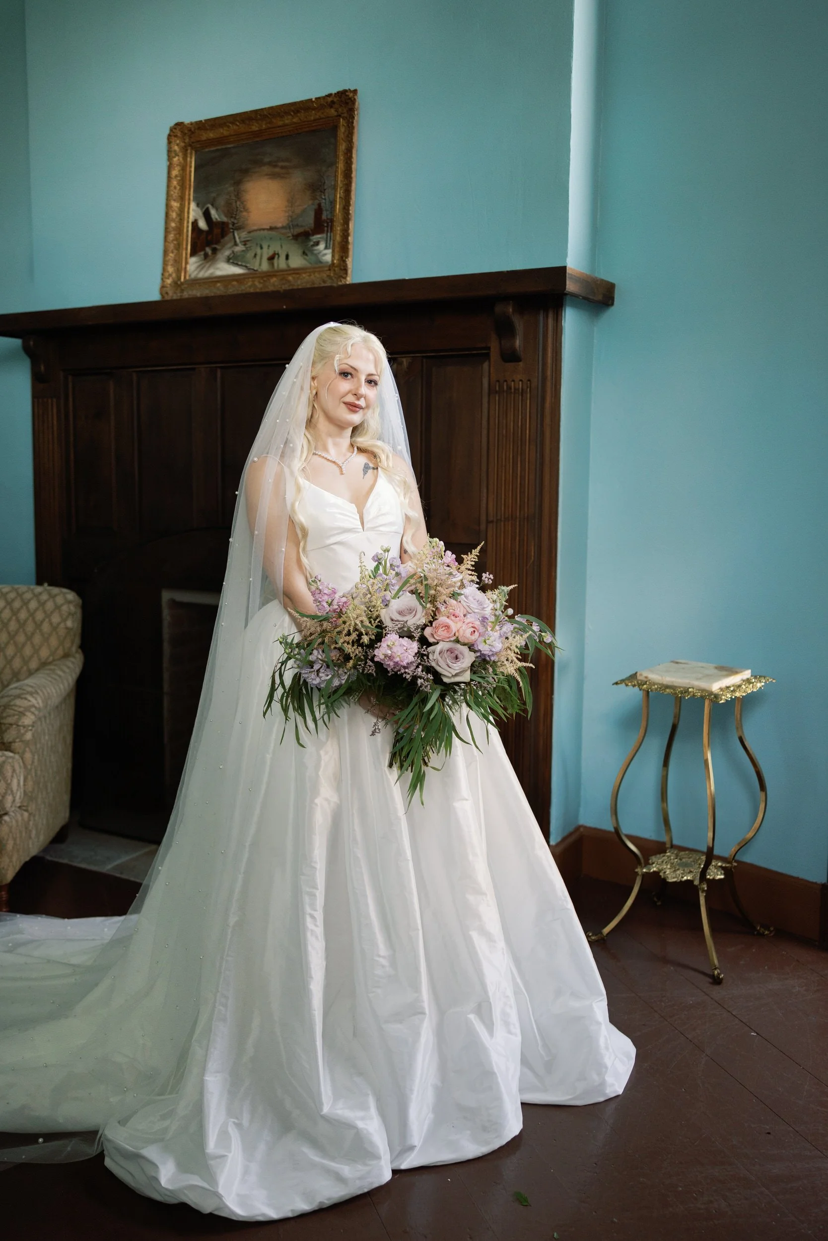 A newlywed in a wedding dress holding a large bouquet of glasses 