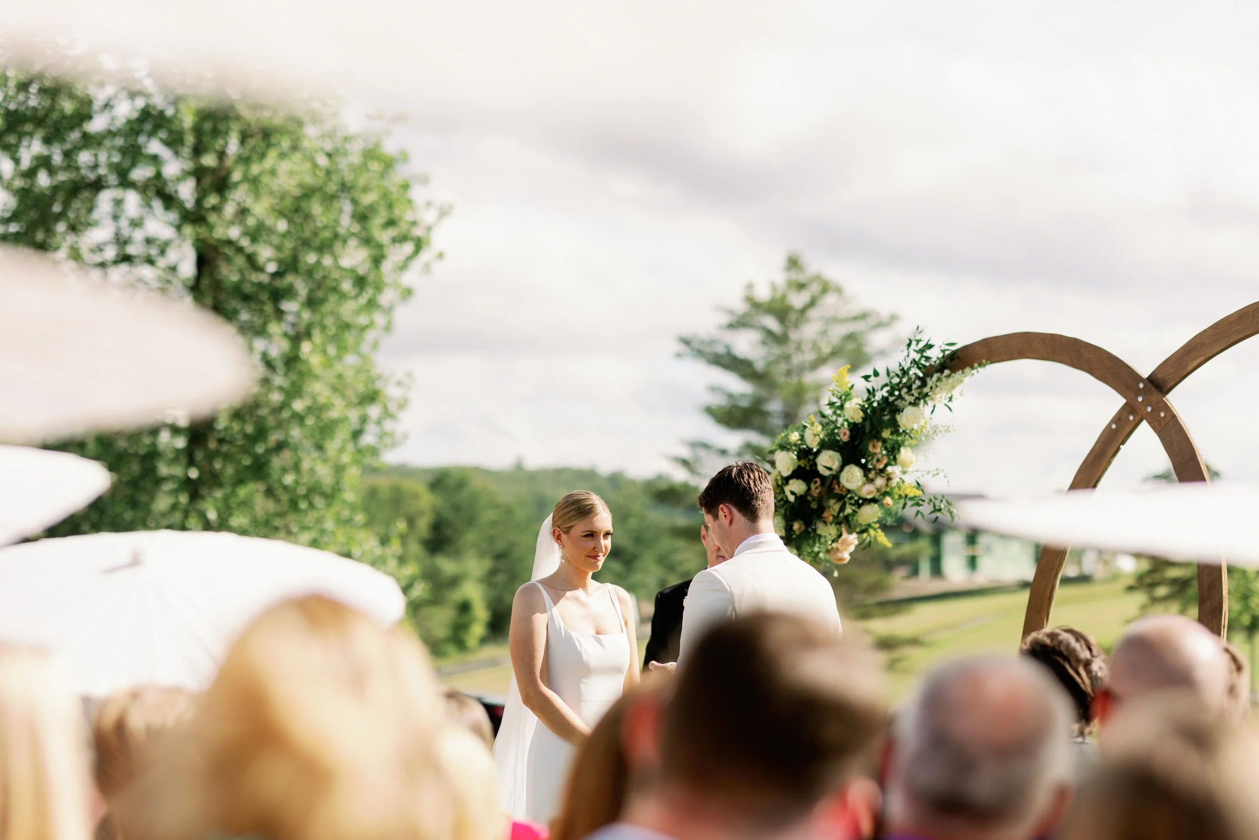 Newlyweds seen over the heads of their guests as they say their vows at their wedding 