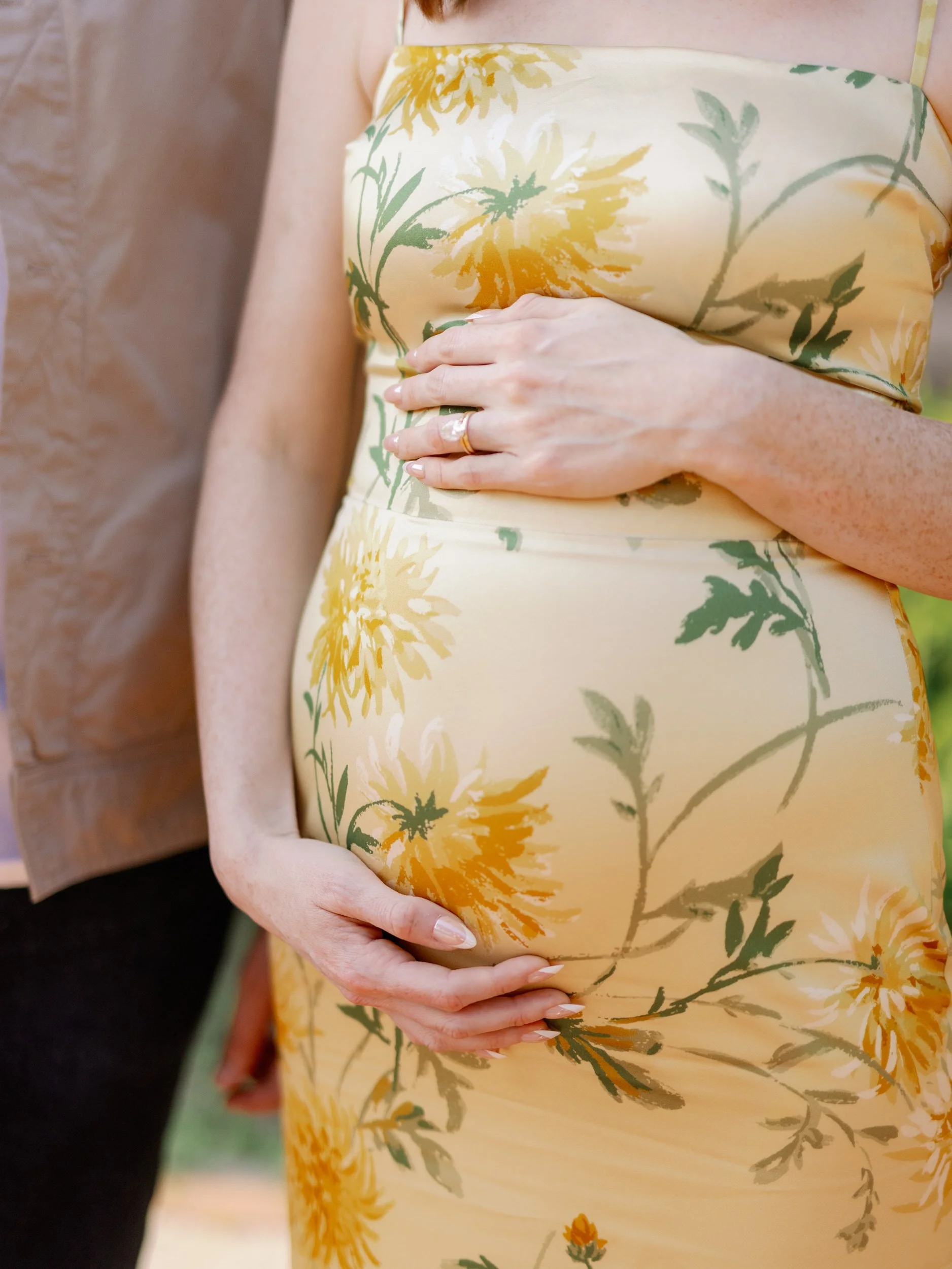 A close up of someones hands around their pregnant stomach