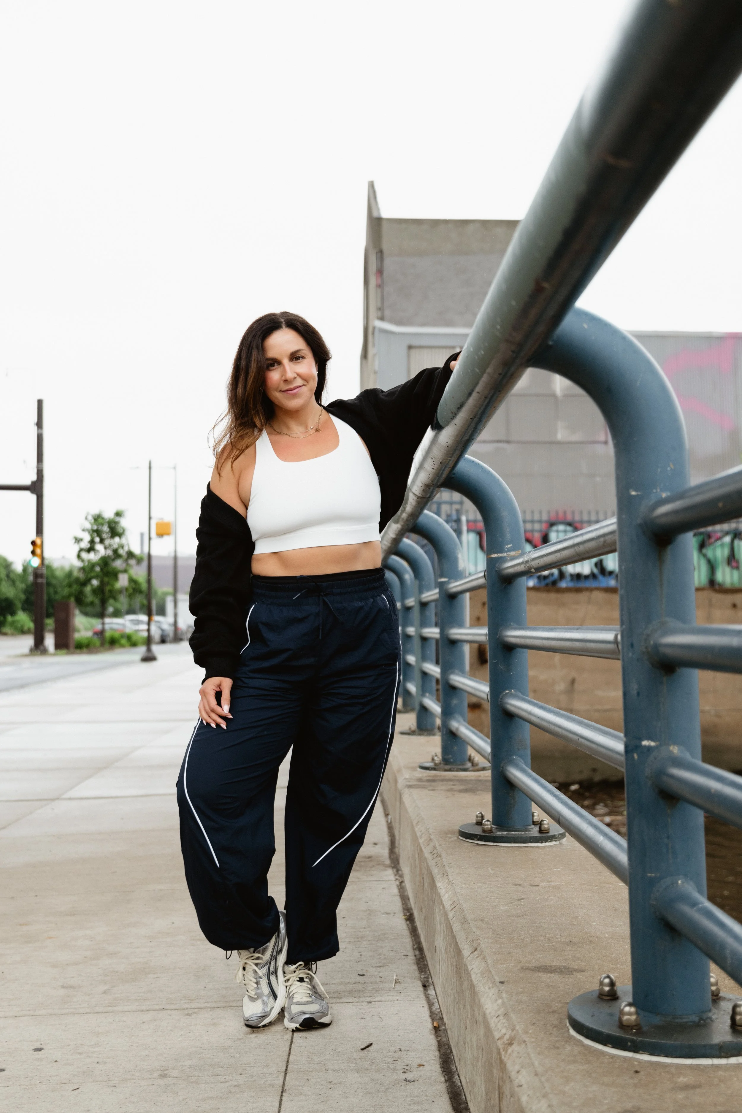 Woman standing next to sidewalk railing