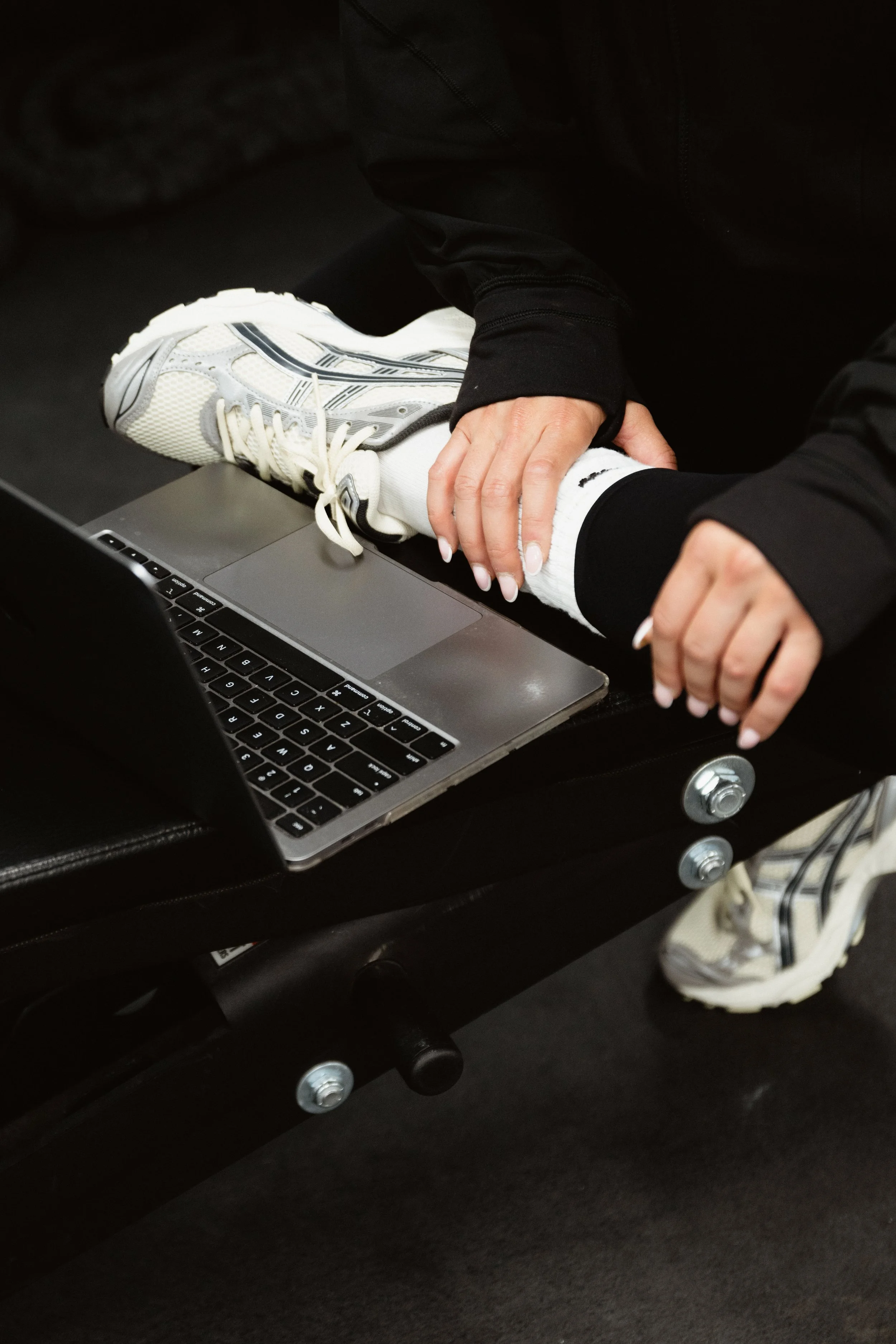 Sitting cross-legged in front of a laptop.
