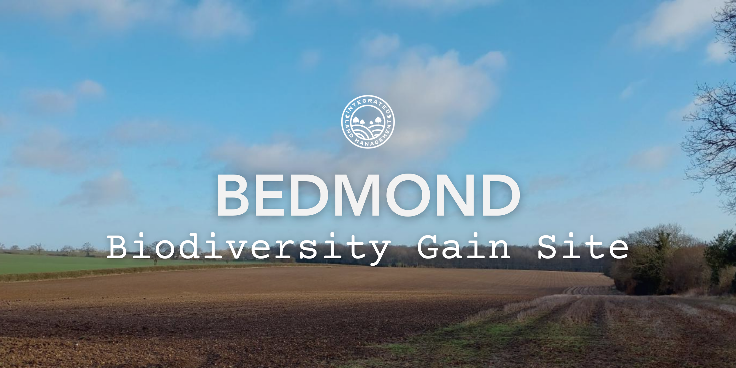 Bedmond Biodiversity Gain Site hero image showing arable farmland in Hertfordshire with open fields and tree-lined boundaries beneath a blue sky.