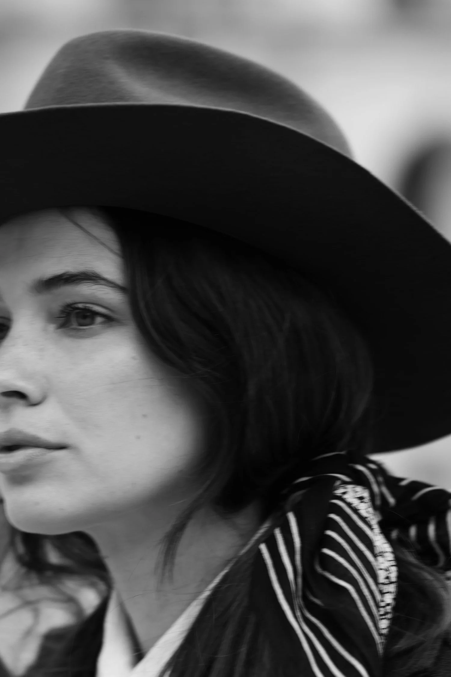 Black and white close-up of a woman wearing a wide-brimmed hat, shown in profile.