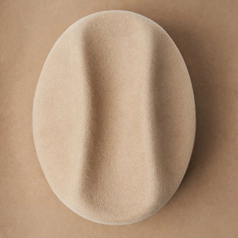Beige felt hat crown shaped in a western style with central crease.