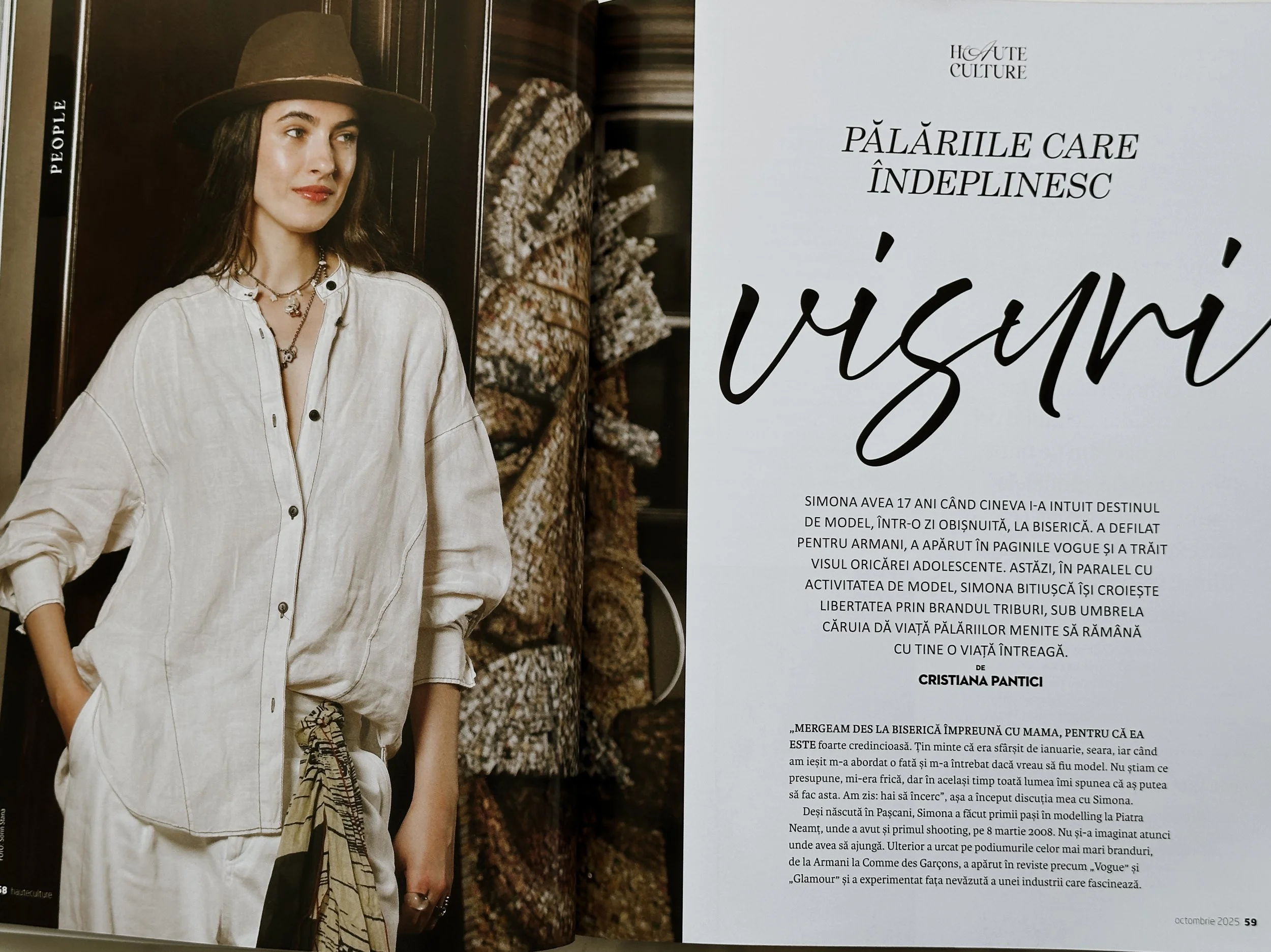 A woman with long brown hair wearing a beige long-sleeve button-up shirt, layered necklaces, and a wide-brimmed hat, standing in front of a dark wooden background with patterned fabric. She has one hand in her pocket and looks slightly to the side. The right page contains text in Romanian about a model named Simona Avea.
