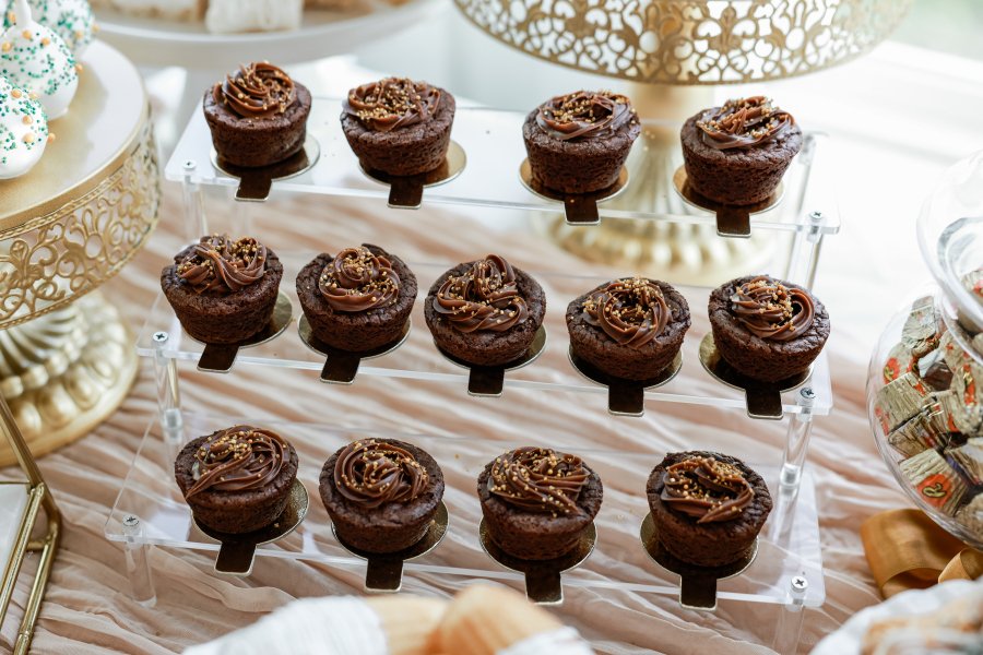 Chocolate mini cupcakes with caramel frosting and sprinkles on a serving tray.