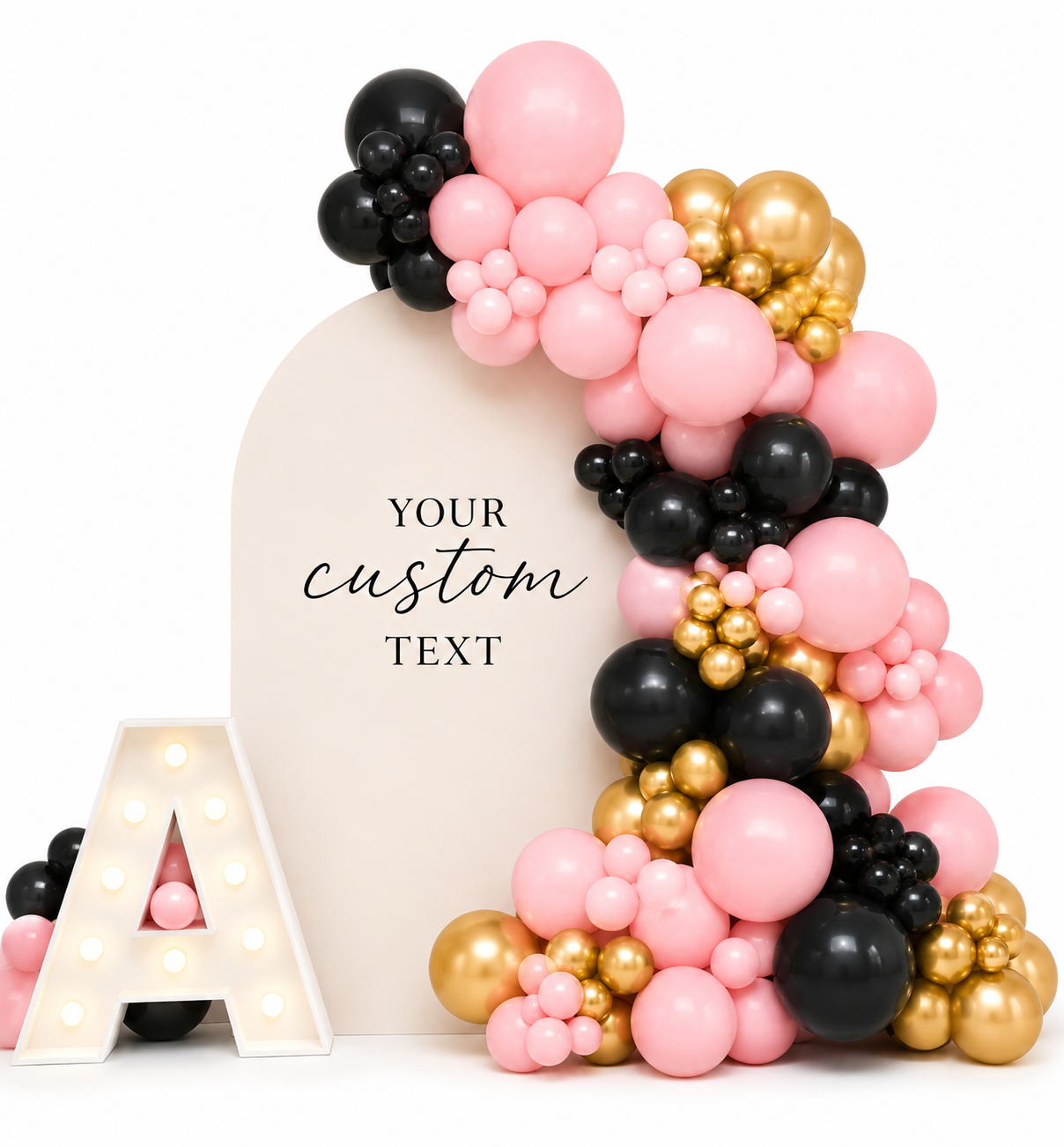 Decorative balloon display with black, pink, and gold balloons surrounding a white oval board with customizable text, a lit marquee letter A at the bottom left, and a white background.