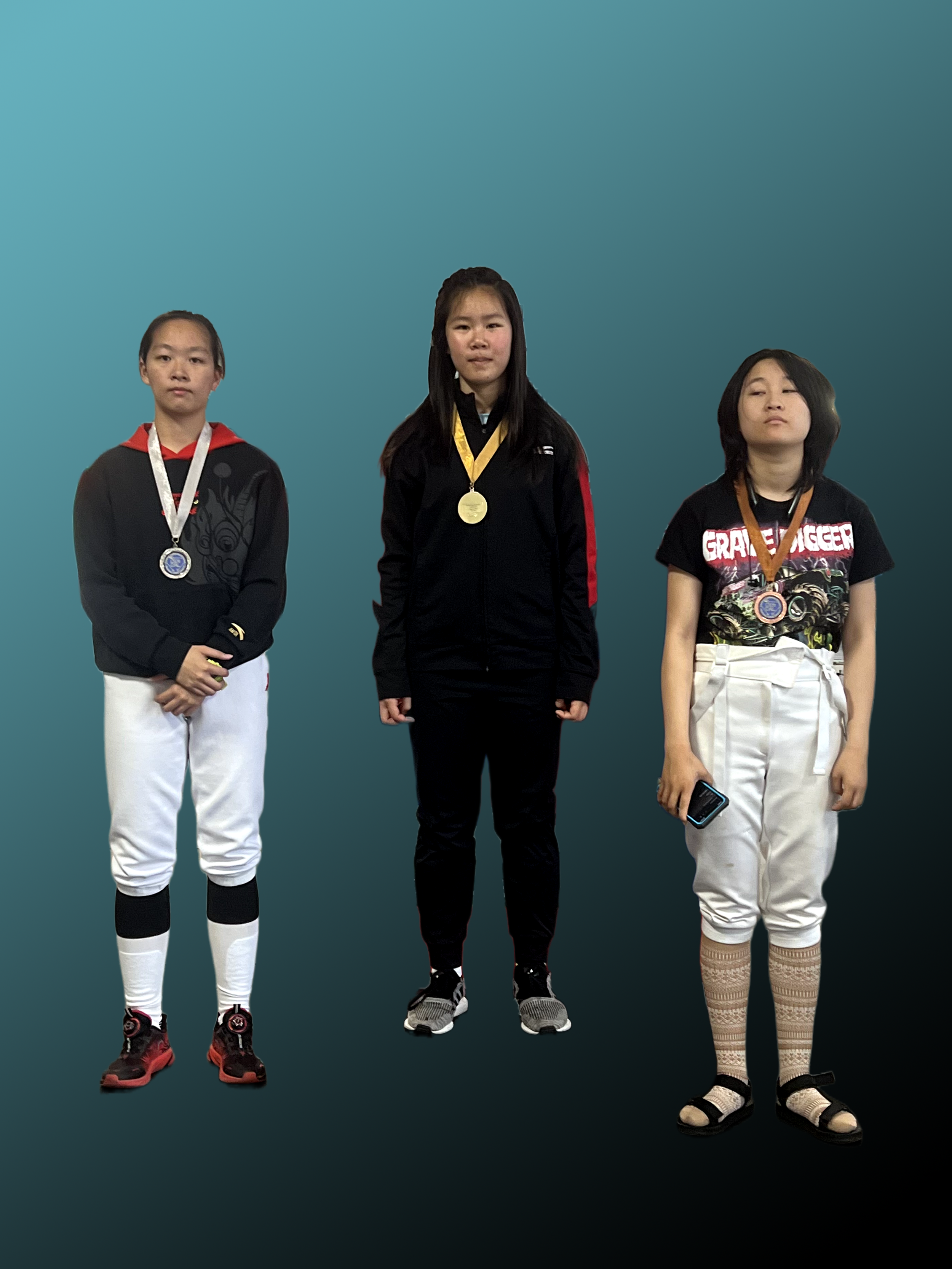 Three young girls standing against a blue background, each wearing medals around their necks, with the girl on the right holding a phone.