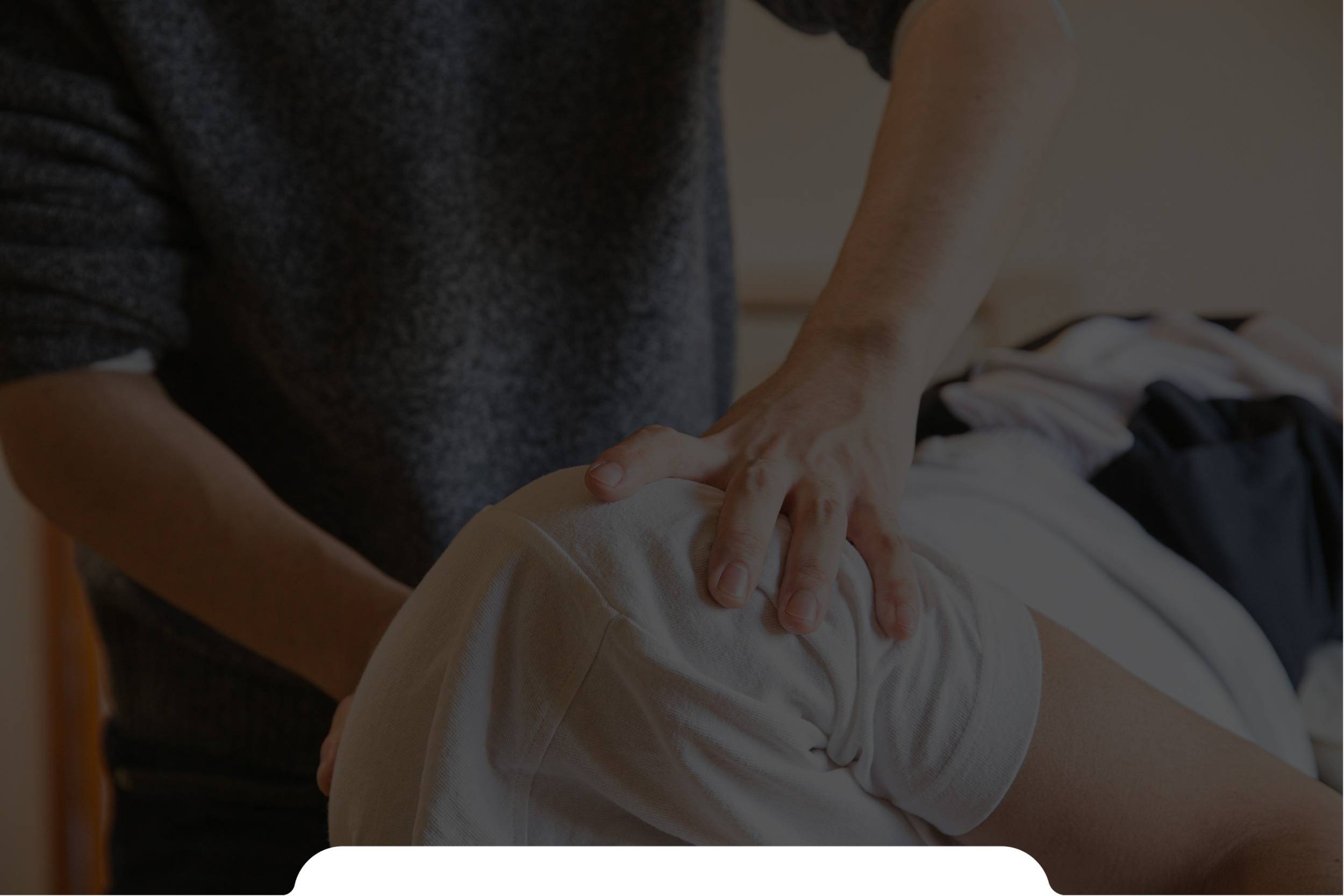 Person receiving a knee massage from a massage therapist in a therapy room.