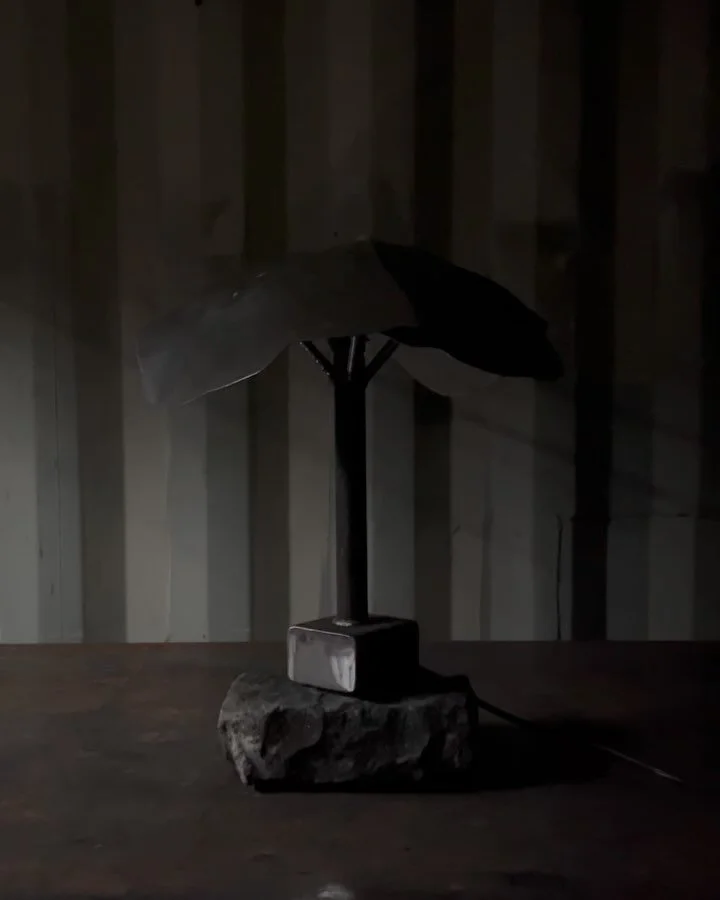 Corten hand formed lamp shade on granite block