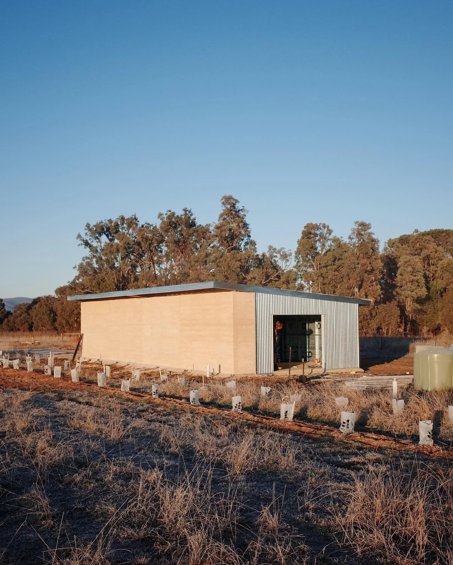Shed construction over the last few days - The exterior rammed Earth wall was constructed a few weeks ago. This week we erected the steel frame, cladded, and attached the gutter and flashings. Next step is the fabrication and installation of the barn