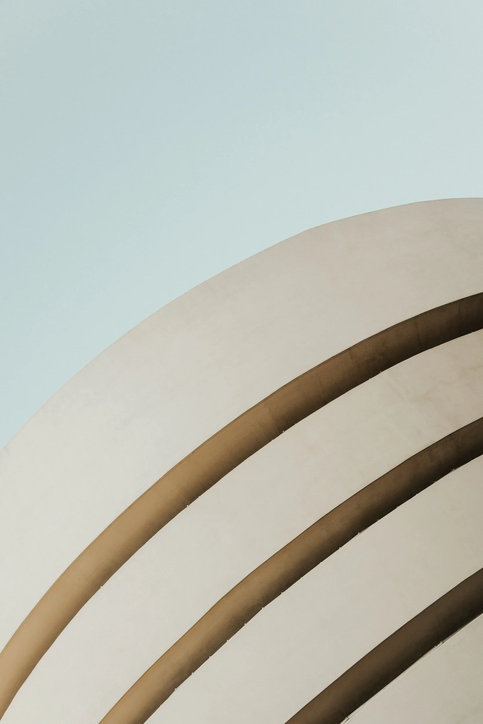 Close-up view of a modern building's ceiling with curved, layered architectural design in neutral tones.