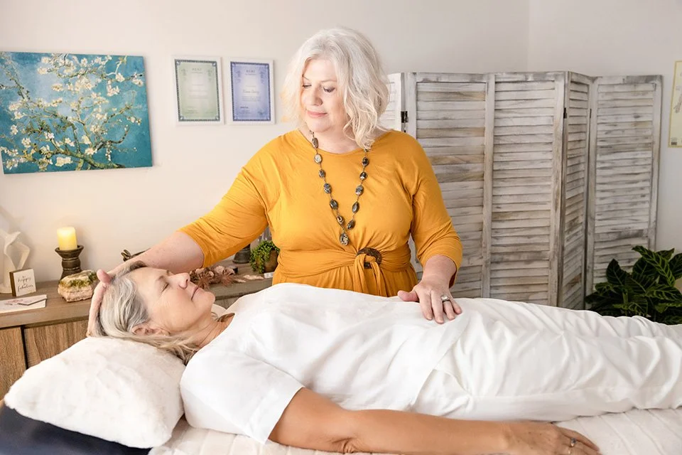 Lady in mustard dress giving a healing session to a client