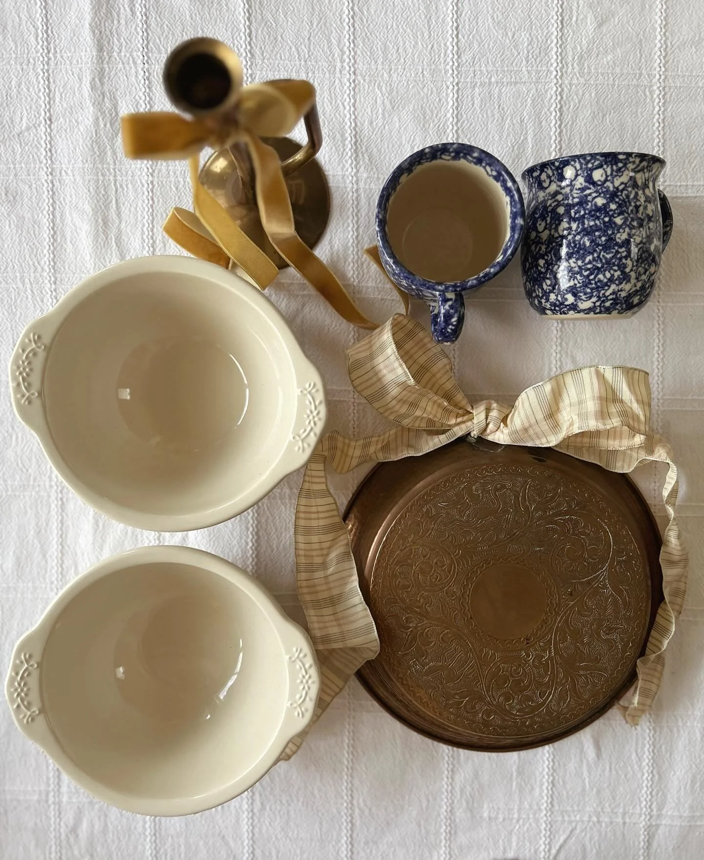 Close up of the treasures found today. Naturally I put bows on the items that were calling for it immediately when I got home.

We have a brass horn candlestick holder, two handmade made spongeware mugs, 2 April Cornell bowls and a copper wall plate.