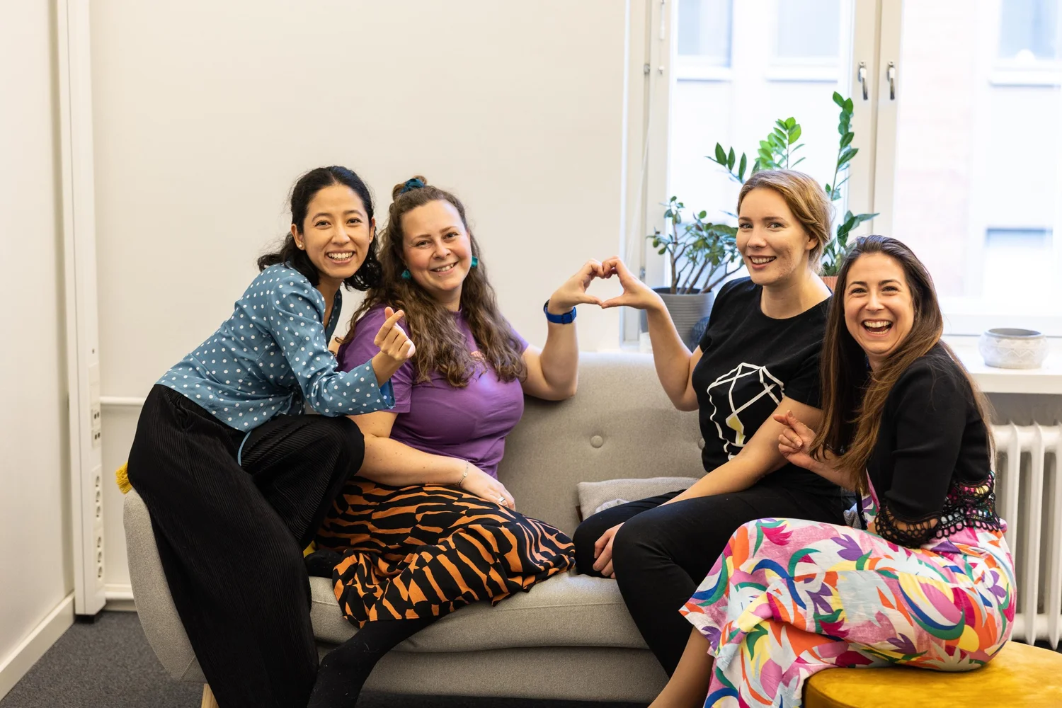 The Finders Seekers employer branding team making heart signs on a sofa