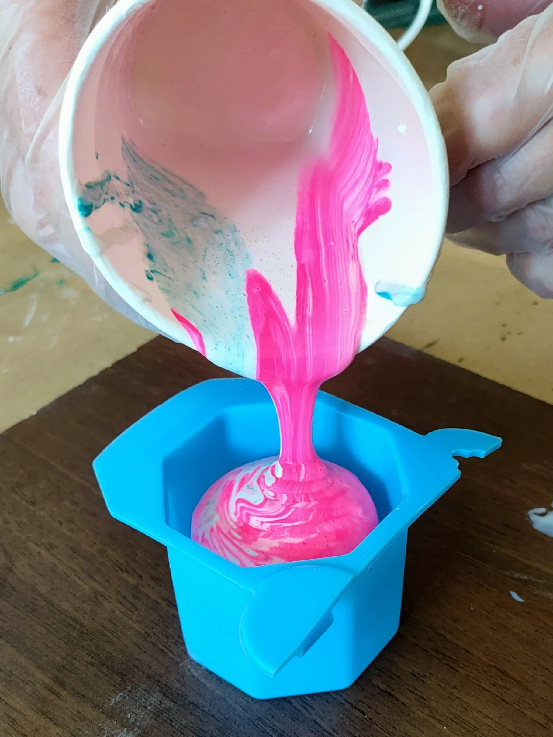 Hand pouring jesmonite liquid into a mould