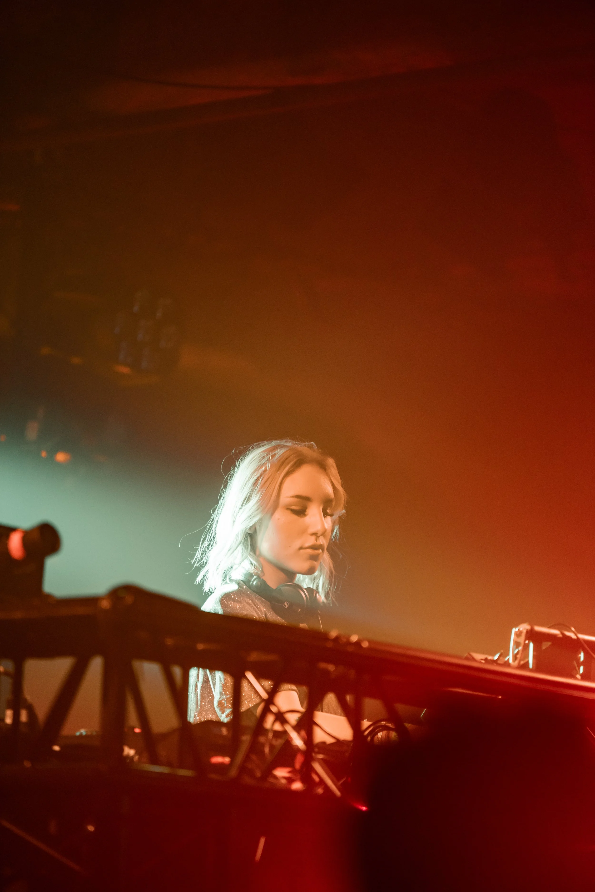 Female DJ performing on stage with colorful lighting