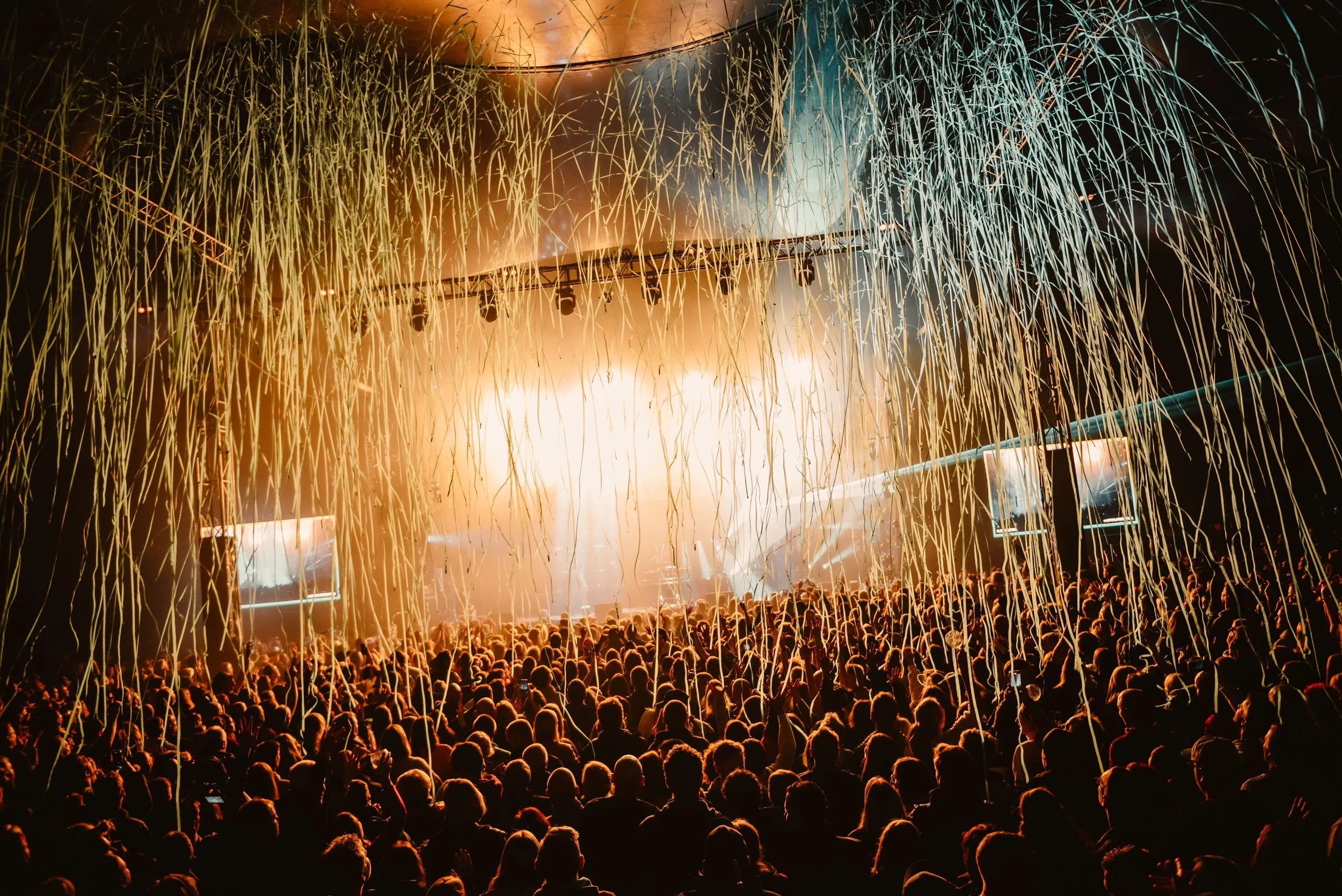 Concert audience with stage lights and streamers falling