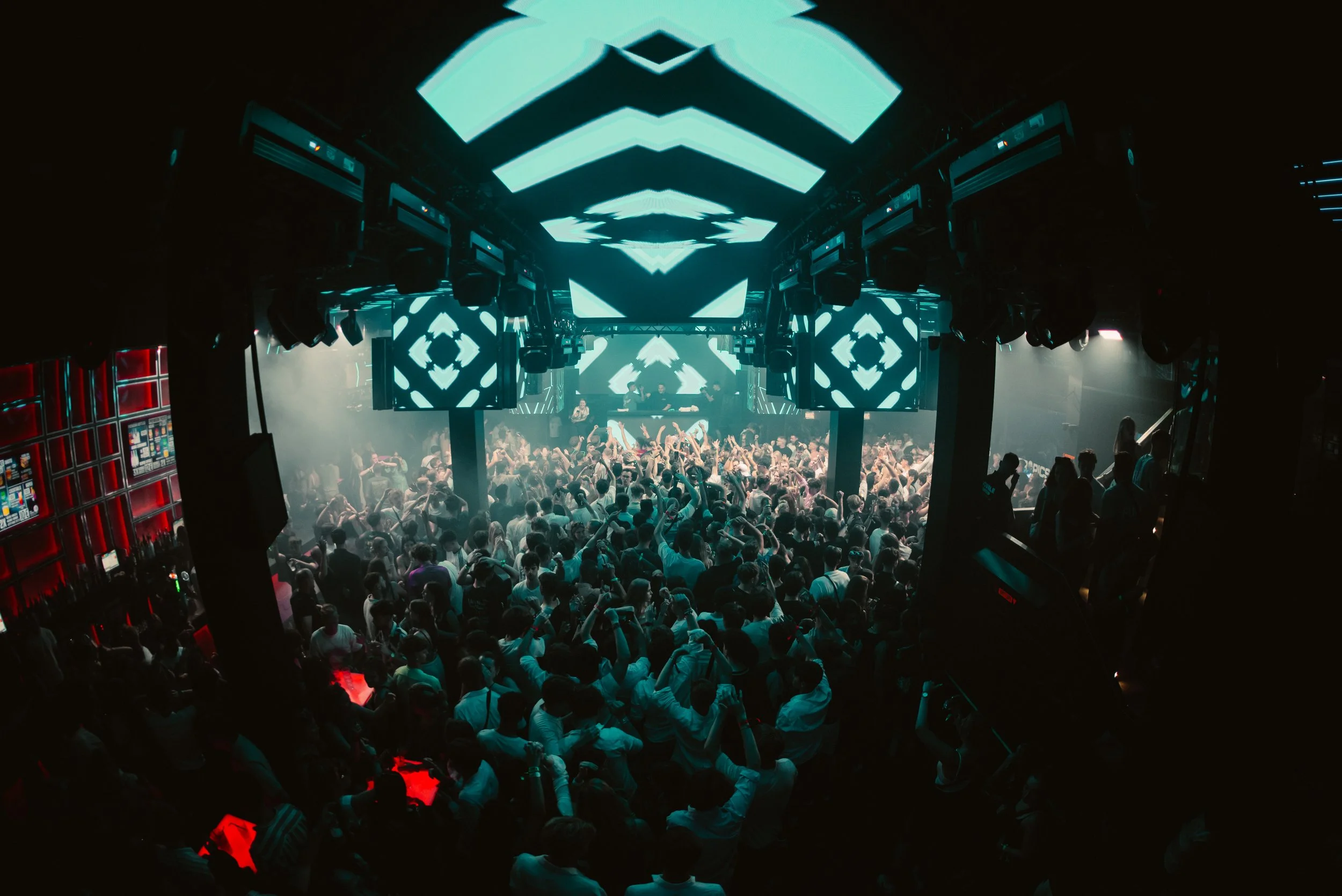 Crowded nightclub with LED lights and DJ