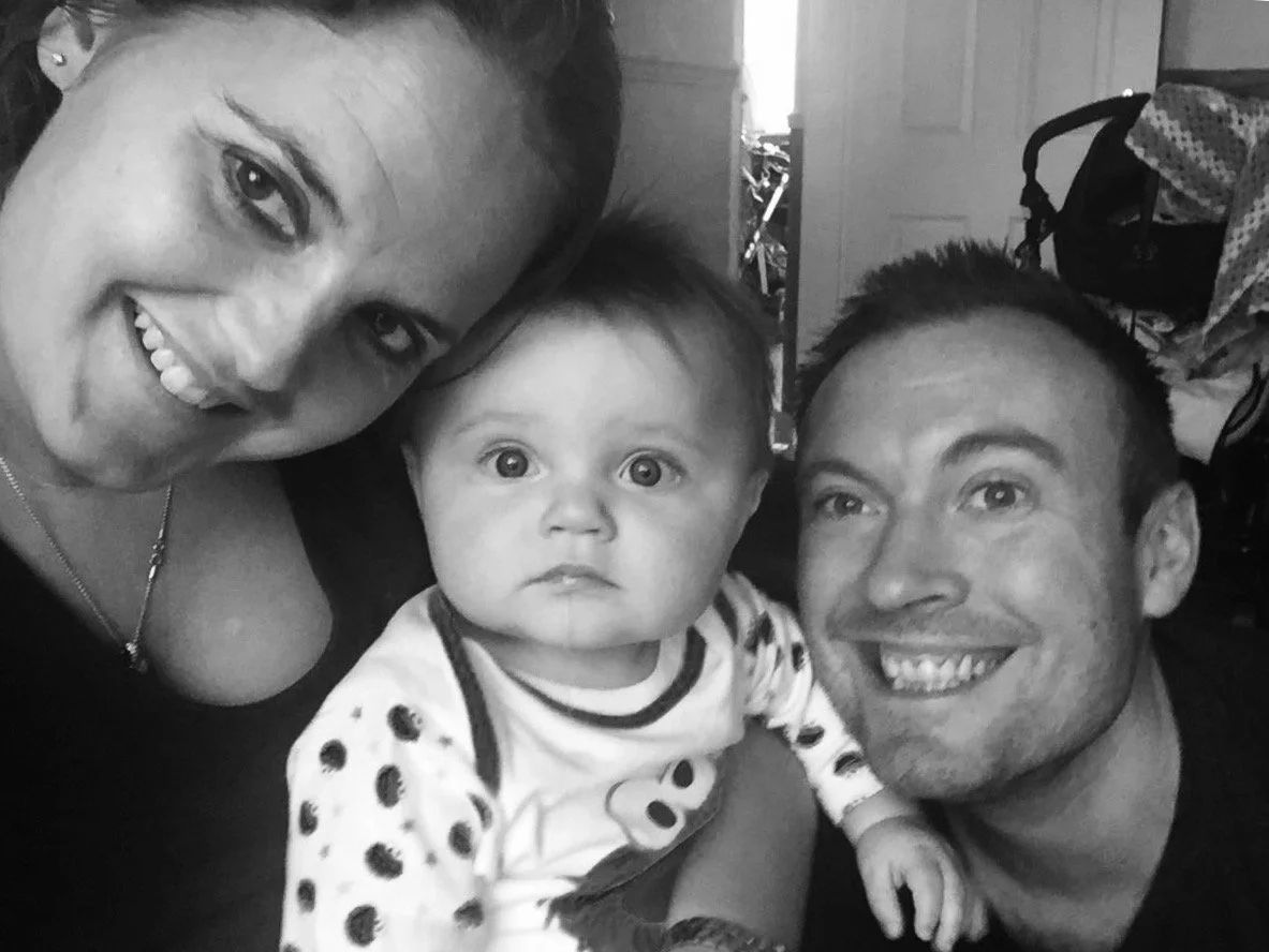 A smiling couple with a baby