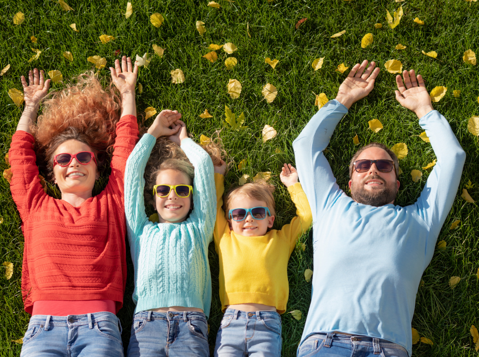Family group wearing sunglasses lying on the grass