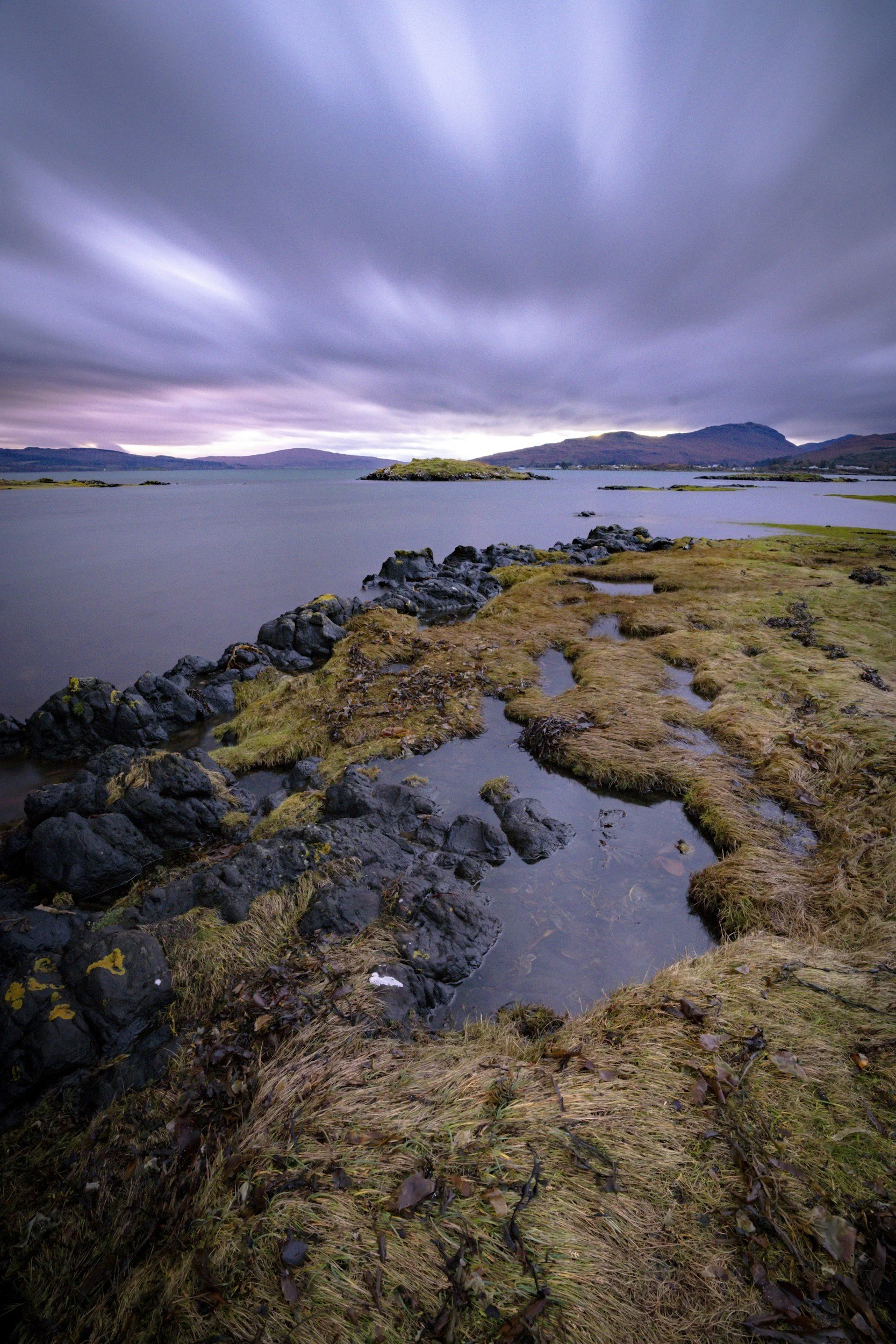 Faint light in the night sky above a remote Scottish landscape