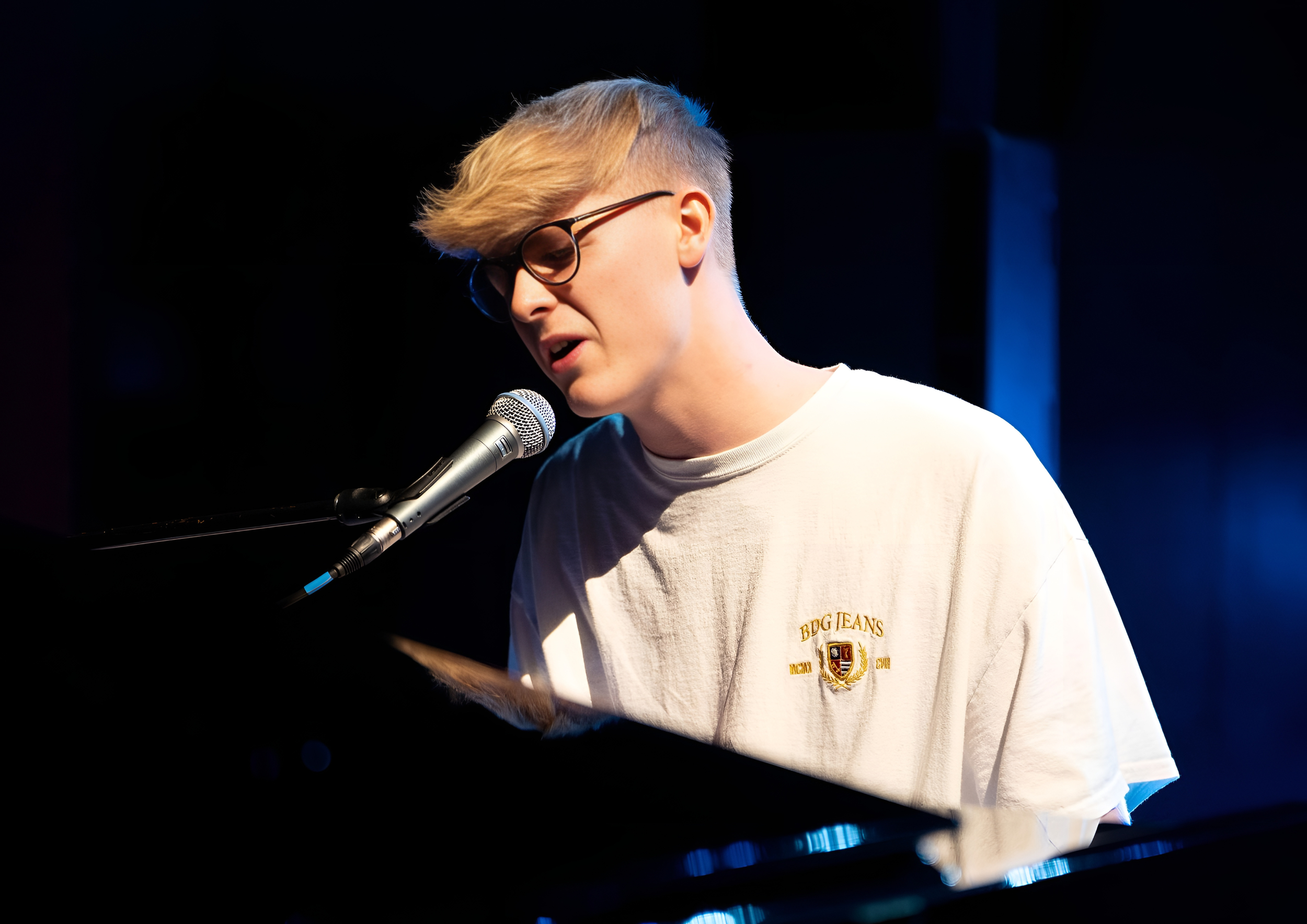 Advanced male student playing at The Anvil Theatre in Basingstoke during a Private Piano Tuition UK concert, showcasing high-standard piano tuition in Hampshire.