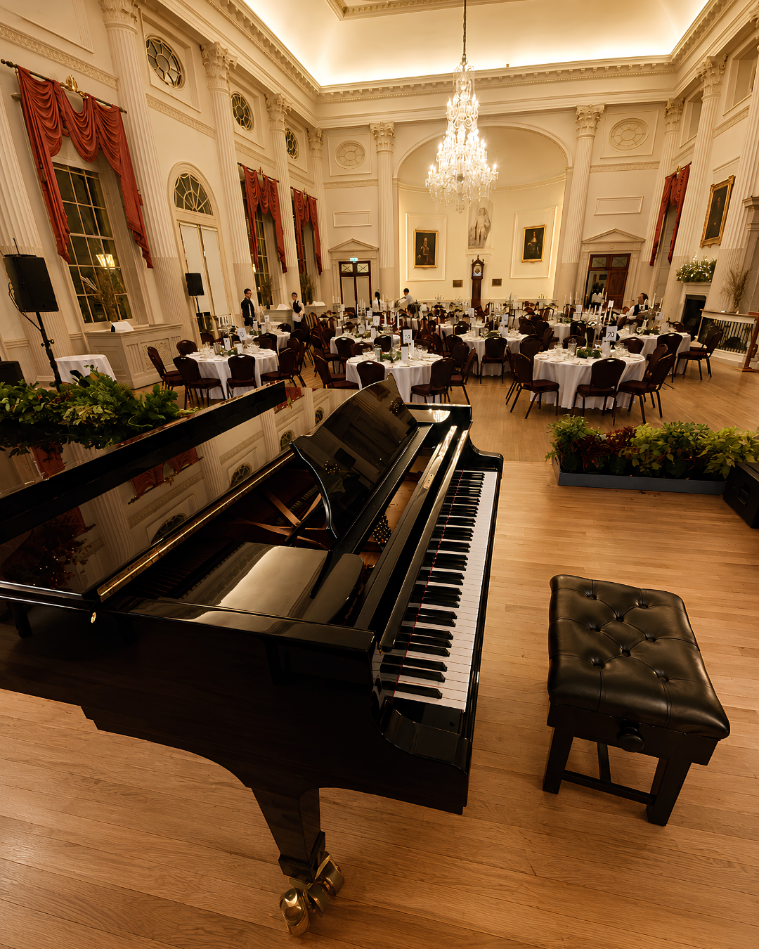 Grand piano set up for a wedding reception with elegant dining tables and floral decorations – live wedding pianist in Berkshire and Hampshire