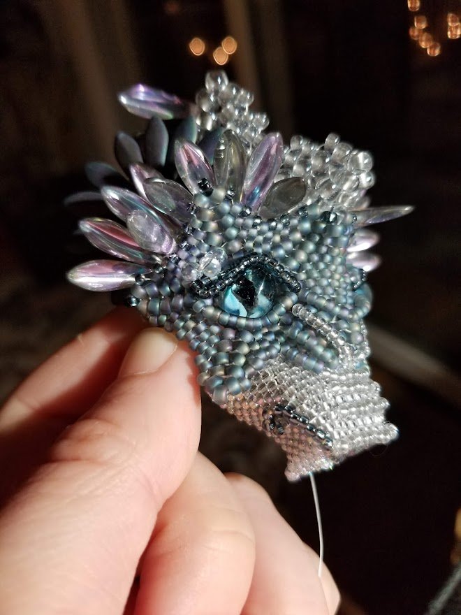 2021 - Empress of the Fog Dragons - this won Gold Medal from FireMountain Gems and was donated to the Museum of Beadwork. Each dragon is contains over 300 beaded scales. The wings are netted glass japanese seed beads and fire polish. The center front