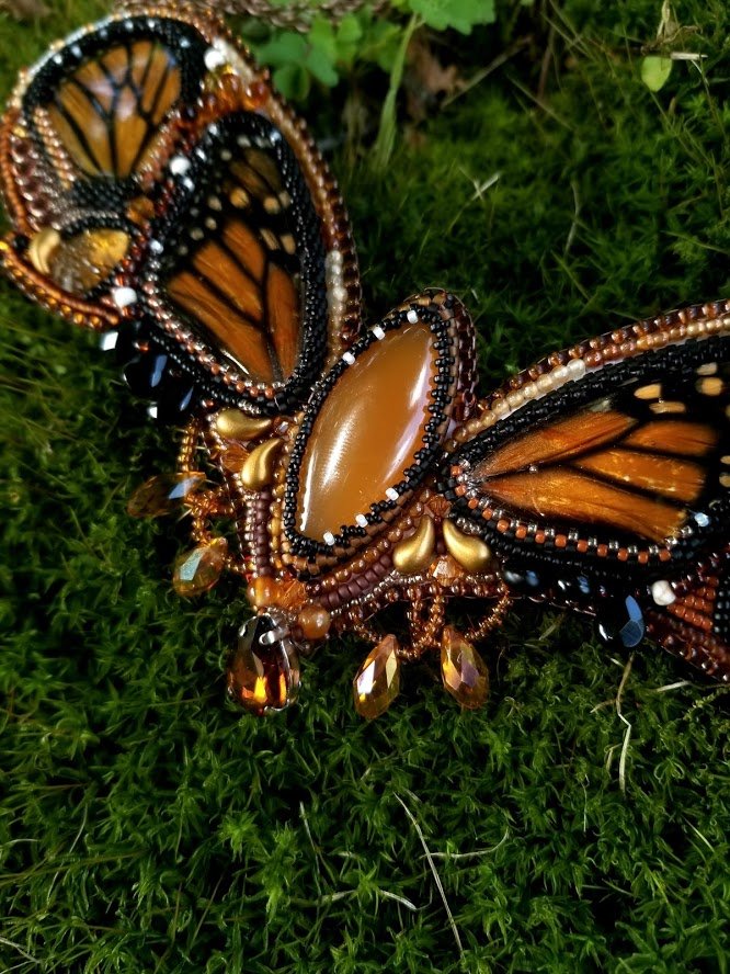 Queen of the Monarchs - preserved monarch butterfly wings from a naturally deceased butterfly are set into this bead embroidery necklace. Orange calcite, alamandine garnet and glass beads make up the rest of the design.