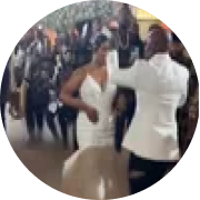 A couple dancing in front of a crowd at what appears to be a celebration or event.
