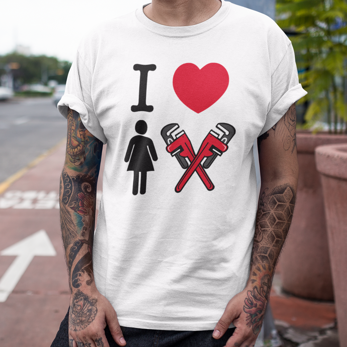 A person wearing a white T-shirt with a graphic design that says "I love" with a red heart symbol, a male figure icon, and two red pipes crossed in an X shape.