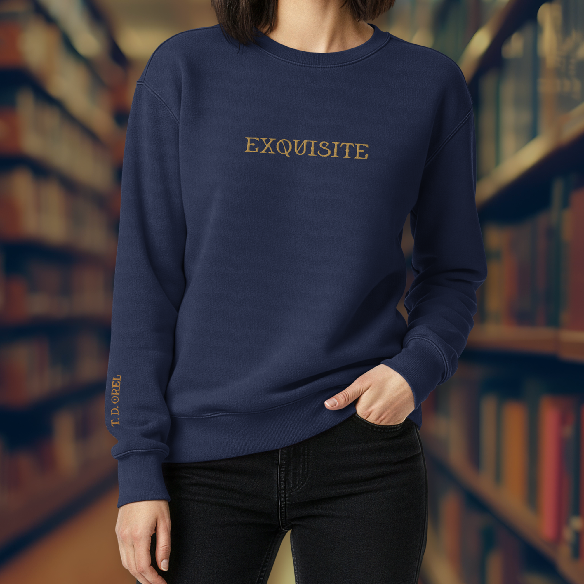 A woman wearing a navy blue sweatshirt with the word 'EXQUISITE' embroidered in gold on the chest, standing in a library with shelves of books in the background.