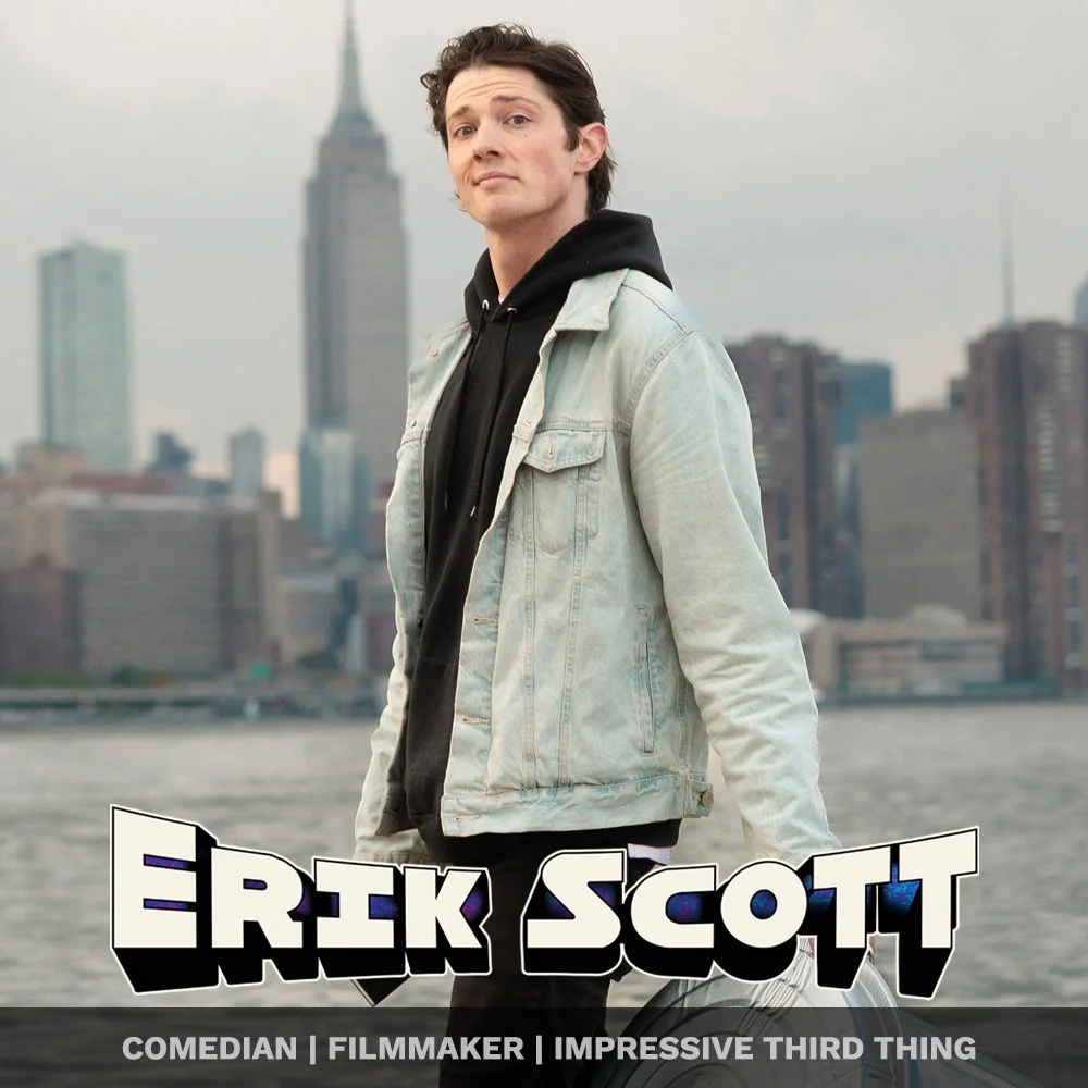 A man standing outdoors near a body of water with city buildings in the background, wearing a black hoodie and a light denim jacket, with the name "Erik Scott" and labels "comedian, filmmaker, impressive third thing" in the foreground.