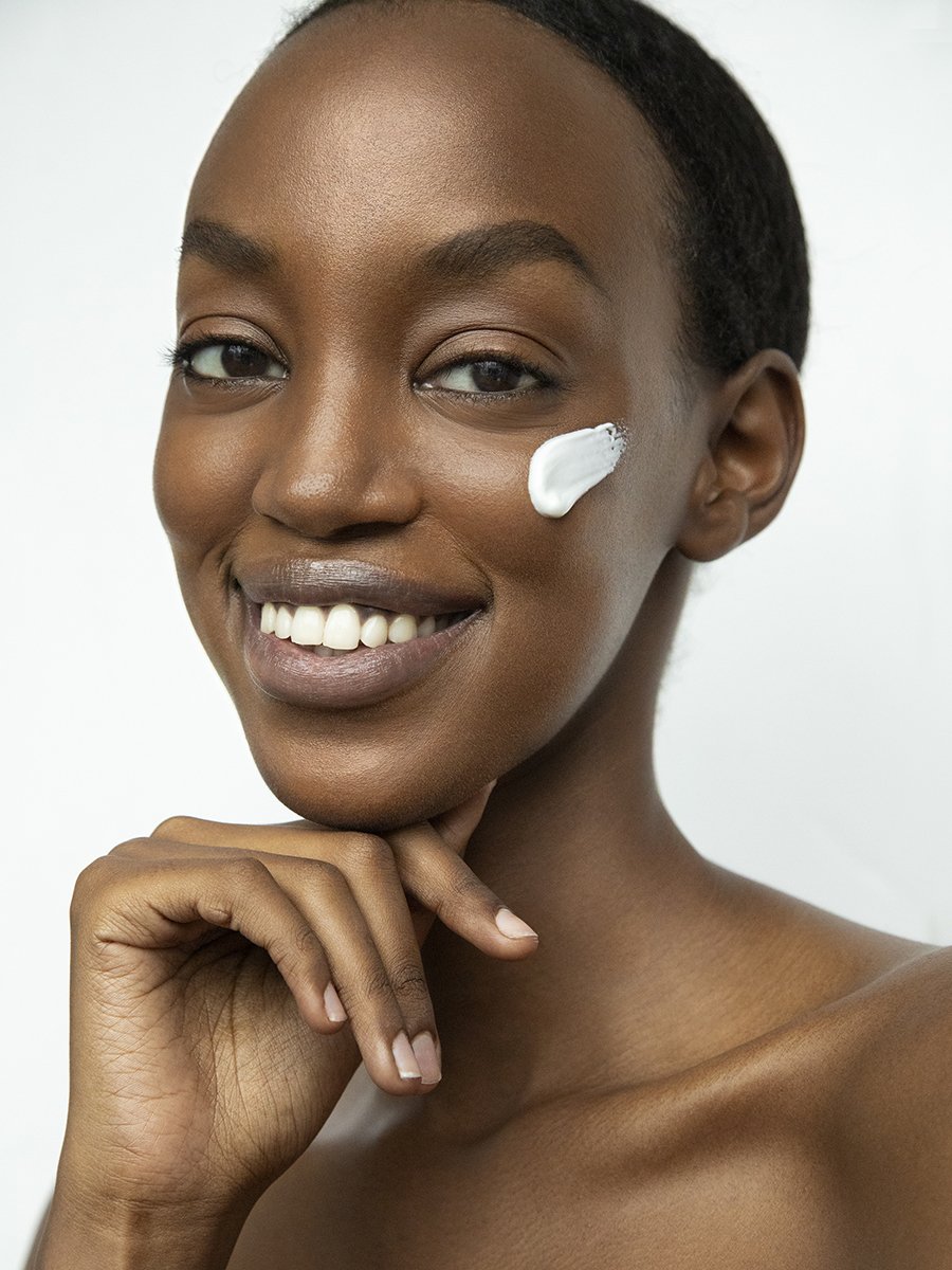 African American beauty photographer Los Angeles clean skincare campaign smiling model cream application