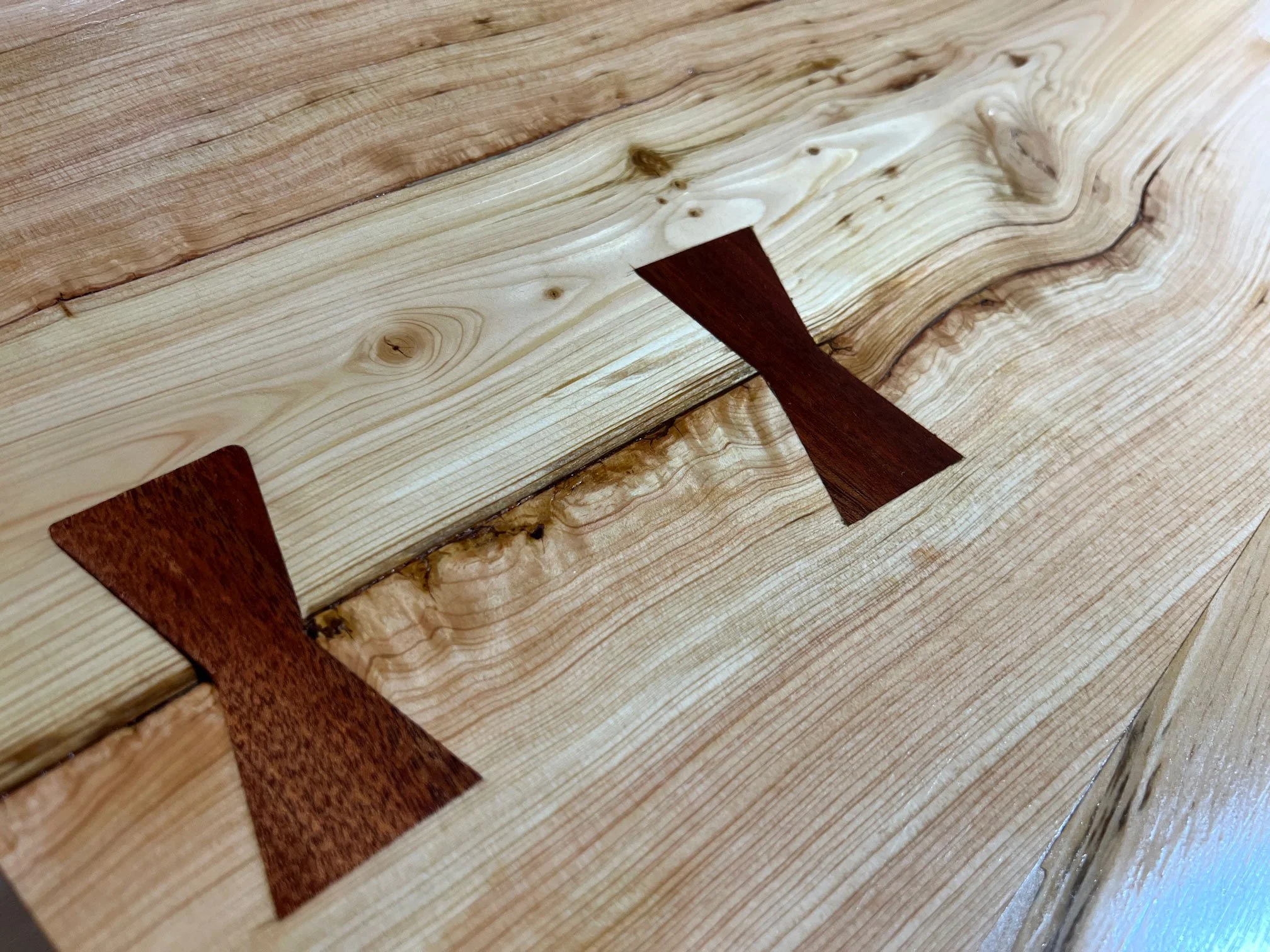 Close-up of wooden surface with inlaid wood arrow designs