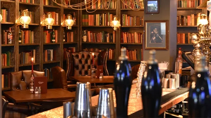 a pub with books and leather chairs